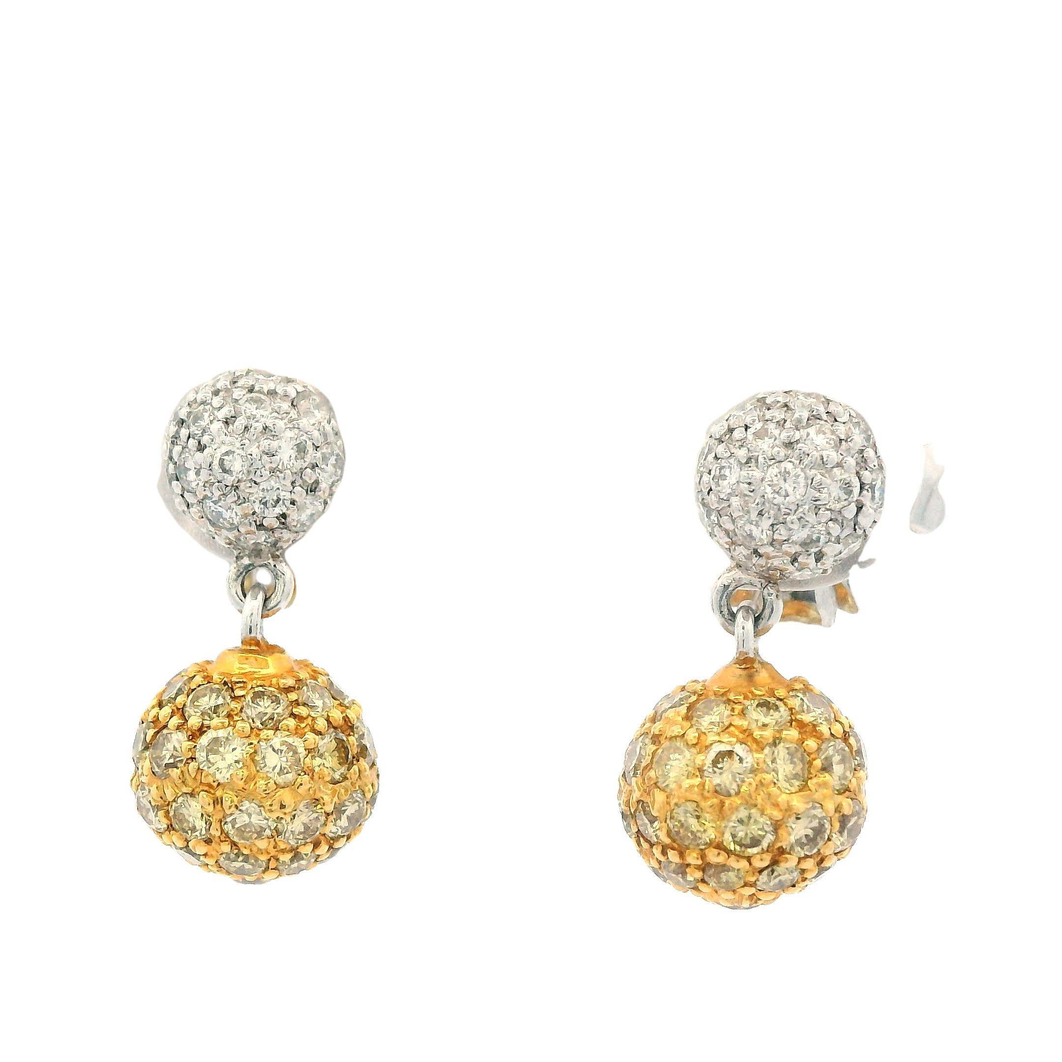 This is a pair of 18k white and yellow gold Sethi Couture fancy intense yellow and white diamond earrings. These earrings are made by the renowned designer, Sethi Couture, who is known for their contemporary glamour that combines vintage and modern