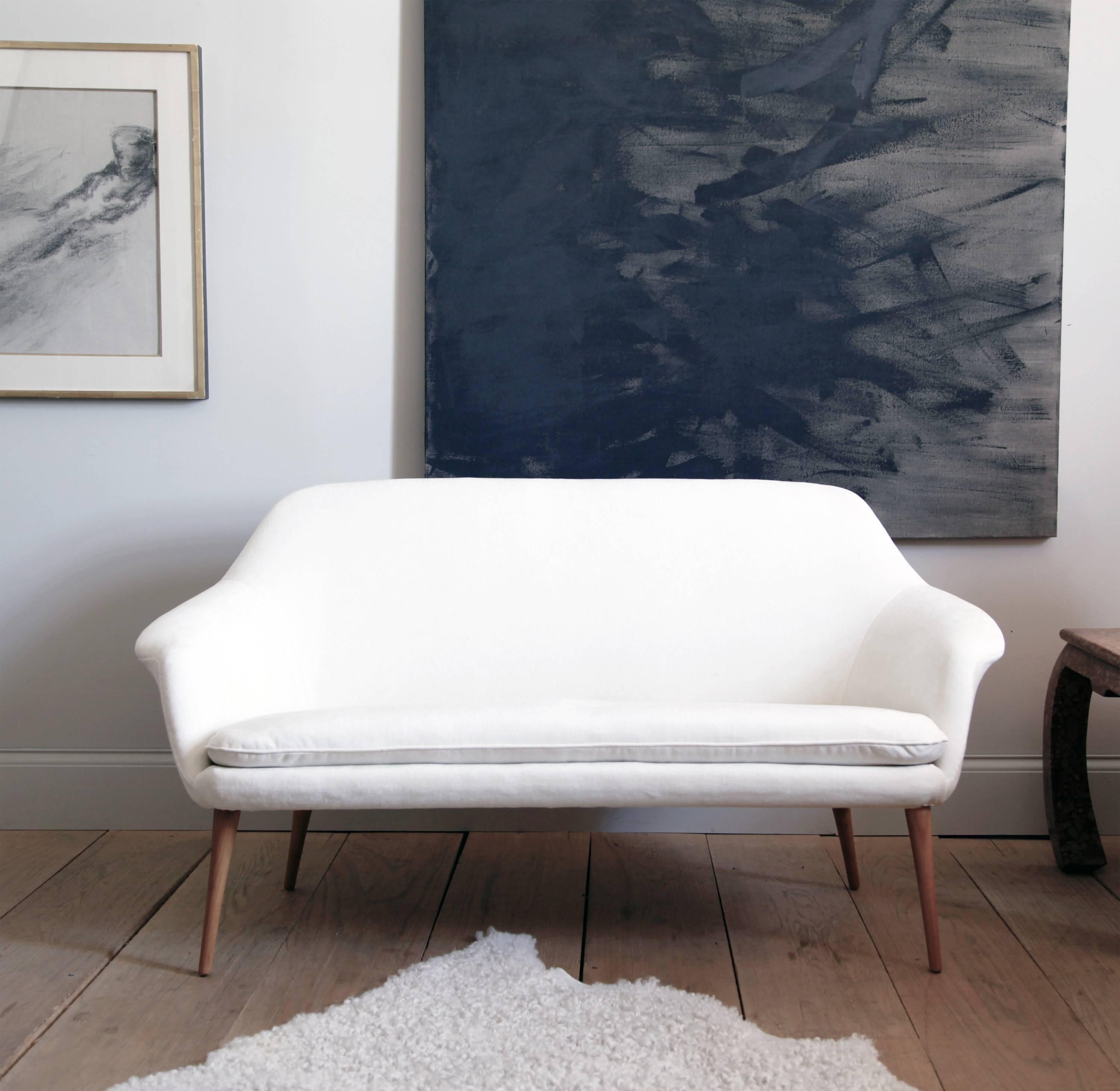 This graceful two-seat sofa was part of the Trivia series, manufactured circa 1950 by Sweden's renowned design retailer, Nordiska Kompaniet. Elias Svedberg was the lead designer behind the NK series. Among his team of 20 assistant designers were