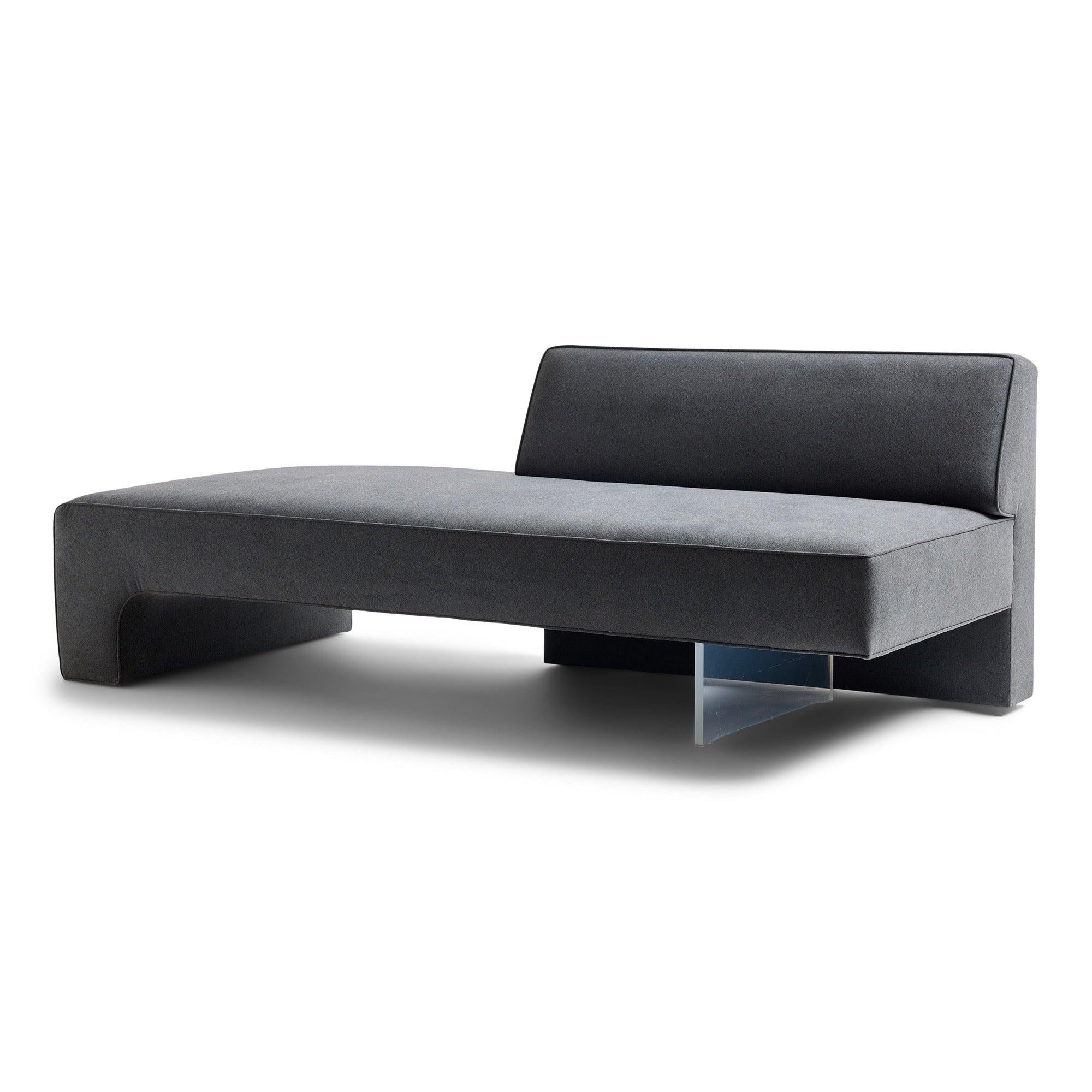 A geometric, uncommon and finely proportioned demi-backed sofa from the Omnibus collection having a waterfall edge and covered in a plush grey velvet upholstery.