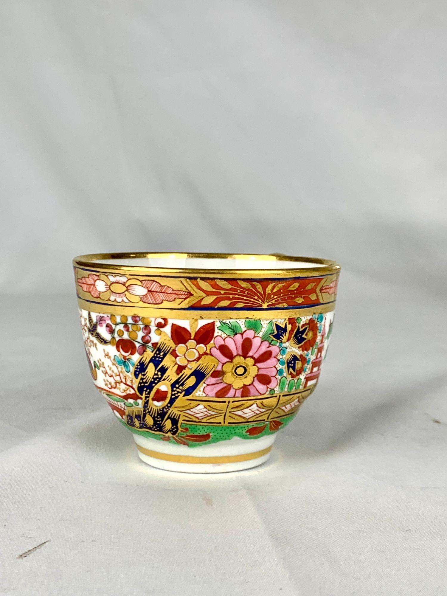 This rare set of seven antique Worcester porcelain cups was hand-painted in the iconic Fence pattern by the Barr Flight Barr period factory in England, circa 1810. Each cup features a finely detailed chinoiserie garden scene with a golden fence,