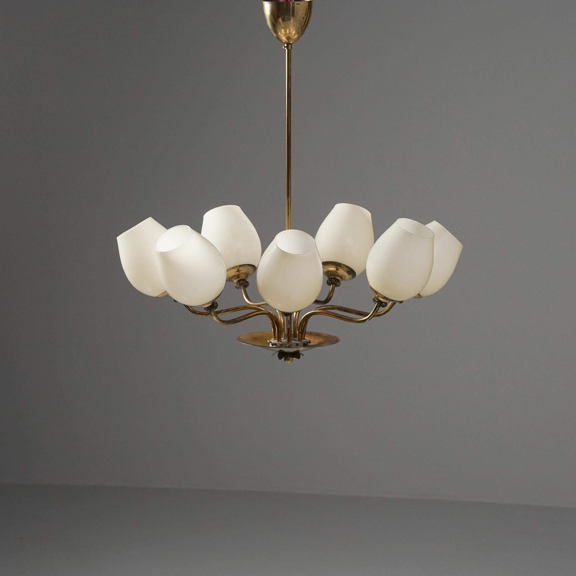 Seven arm chandelier, attributed to Itsu, 1950s. Brass frame, opaline glass shades. Good vintage condition, minor patina consistent with age and use. Beautiful and timeless Scandinavian Modern piece. 