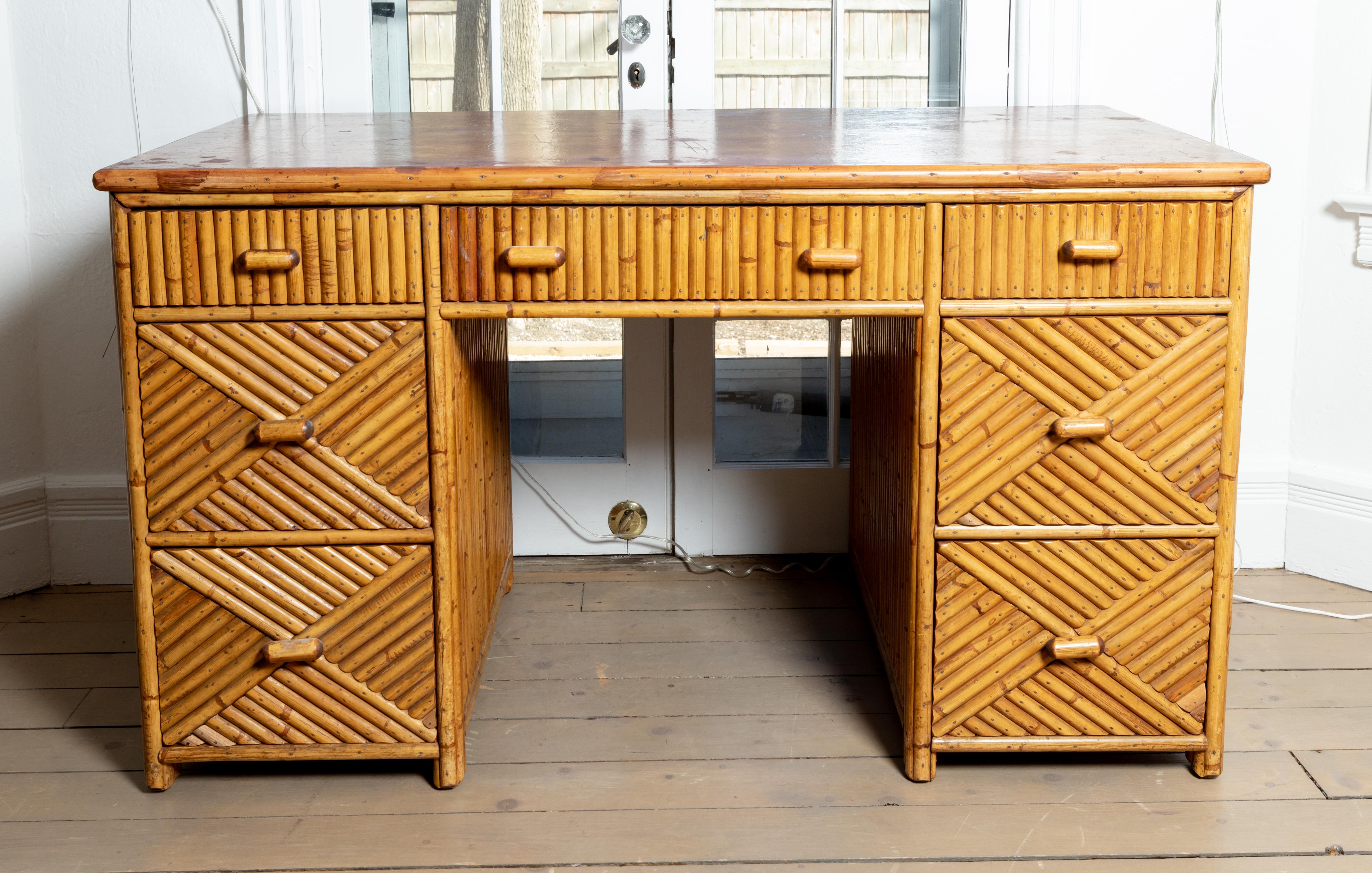 Seven-drawer bamboo desk with glass top.