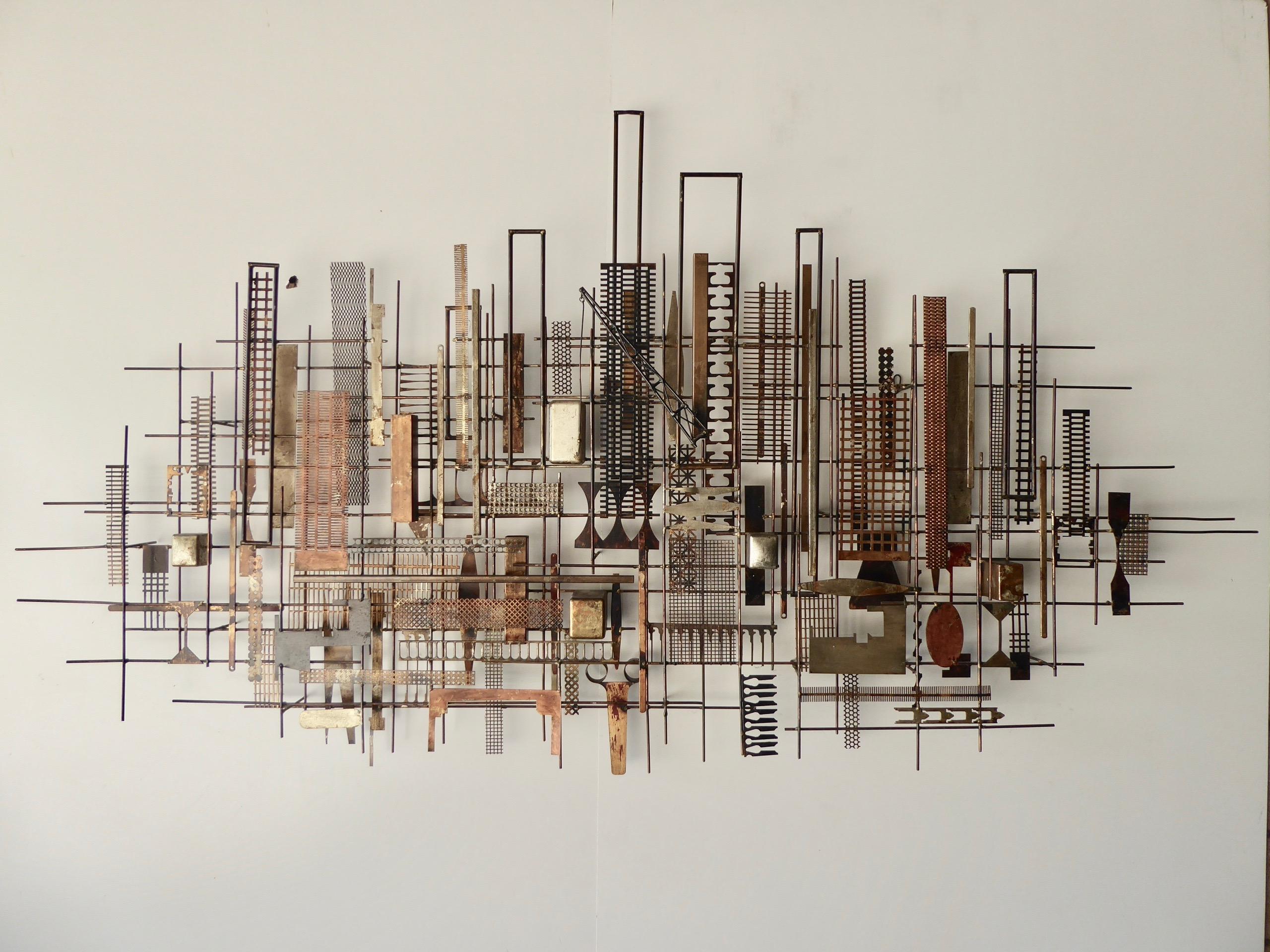 A joyful, super large-scale, fantasy city skyline wall sculpture (circa 1970) by American artist William Bowie, (1926-1994). This over seven foot wide Brutalist metal wall sculpture is one of the largest pieces ever done by this artist and is most