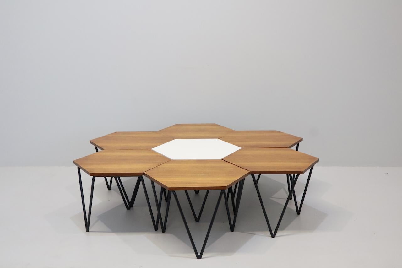 The set of seven modular coffee tables in metal, black formica laminate and oakwood designed by Gio Ponti for I.S.A. Italy, circa 1950. Modular tables have a hexagonal shape and have triangular metal legs. The metal bases are executed in black