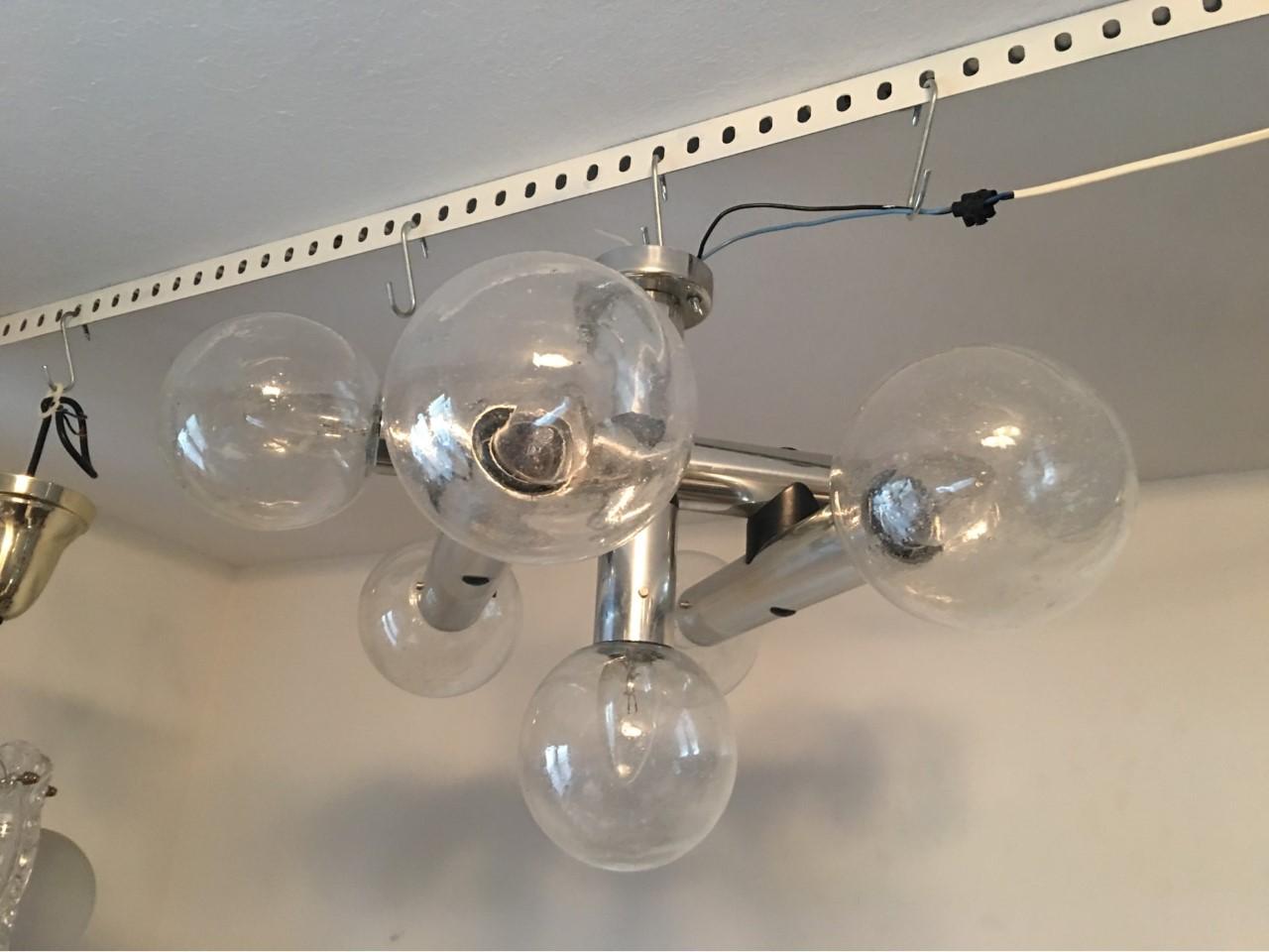 From the 1960s-1970s era. A rare seven glass Sputnik flush mount chandelier from Austria. The aluminum frame hold seven hand blown glass air bubbles.
Each bubble is 4.75 inches in circumference. The wall/ceiling mount is 3 1/8 inches. This great