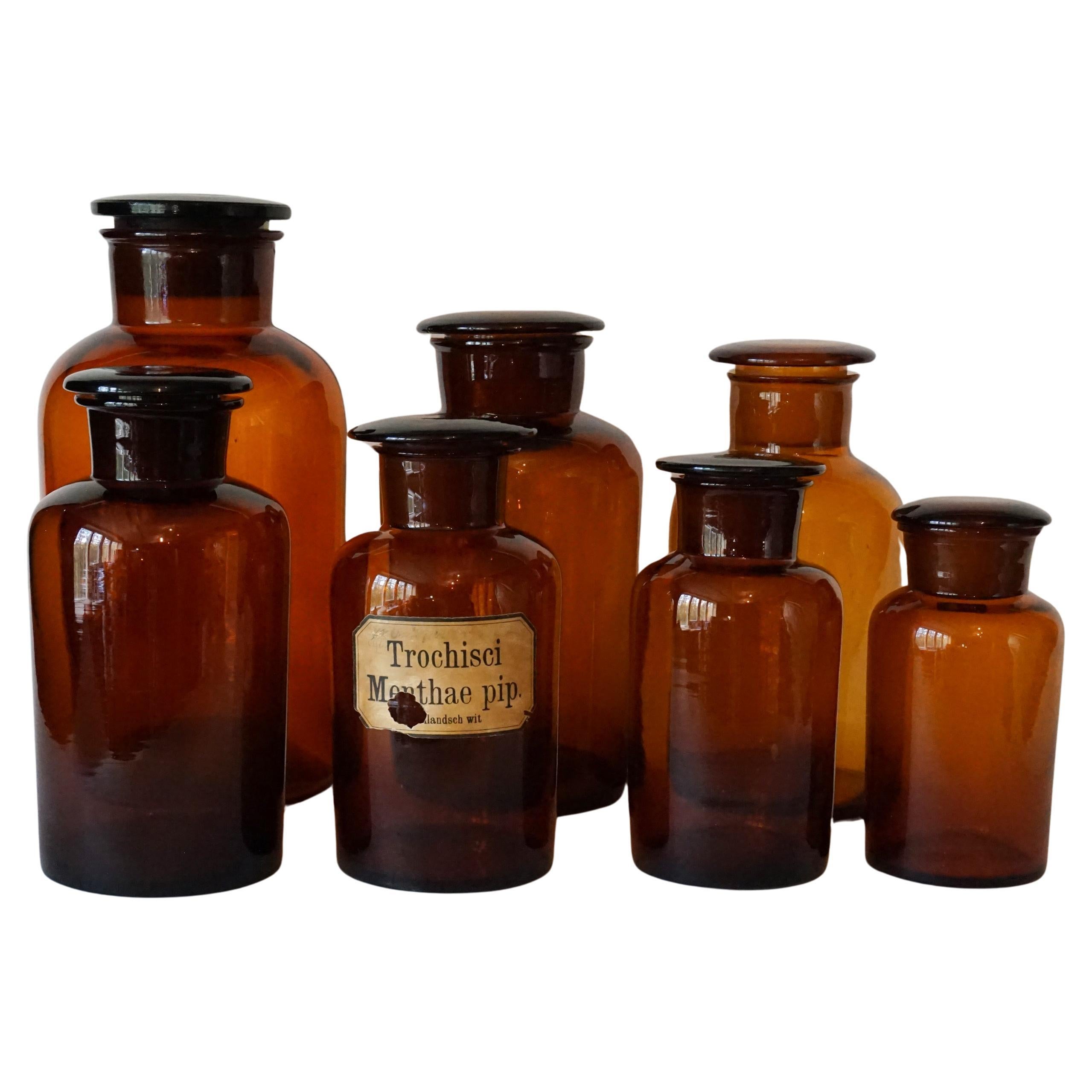 Sette grandi vasi da farmacia in vetro ambrato marrone tedesco della metà del XX secolo con coperchio in vendita