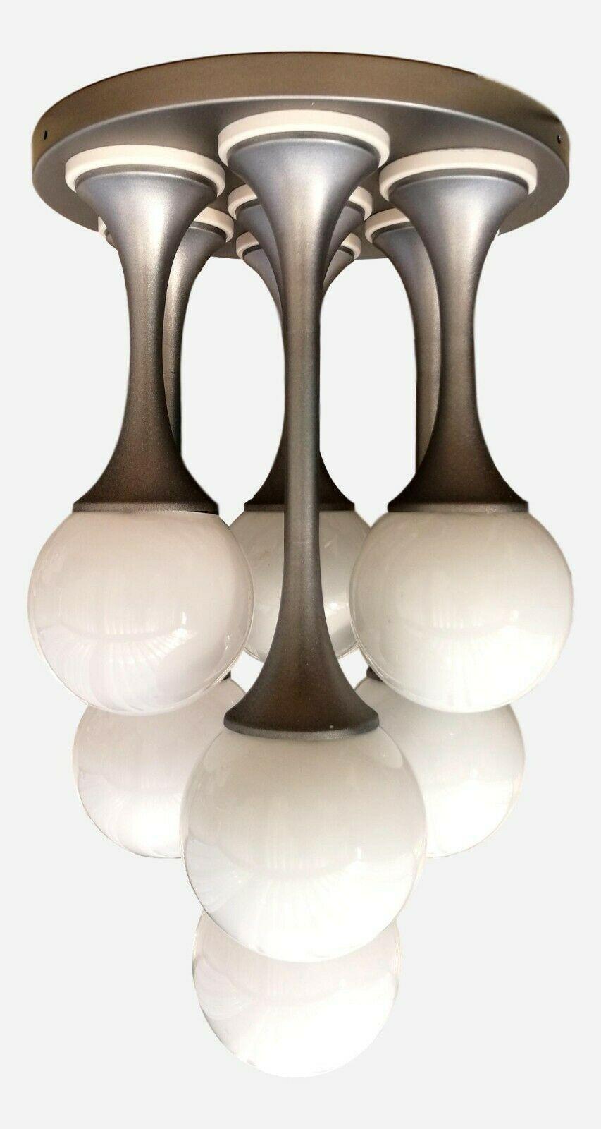 Splendid original lamp from the 70s, initially probably born as a chandelier and later used as a table lamp, probably produced by goffredo reggiani , consisting of a steel base and seven trumpet-shaped diffusers with as many milky white opaline