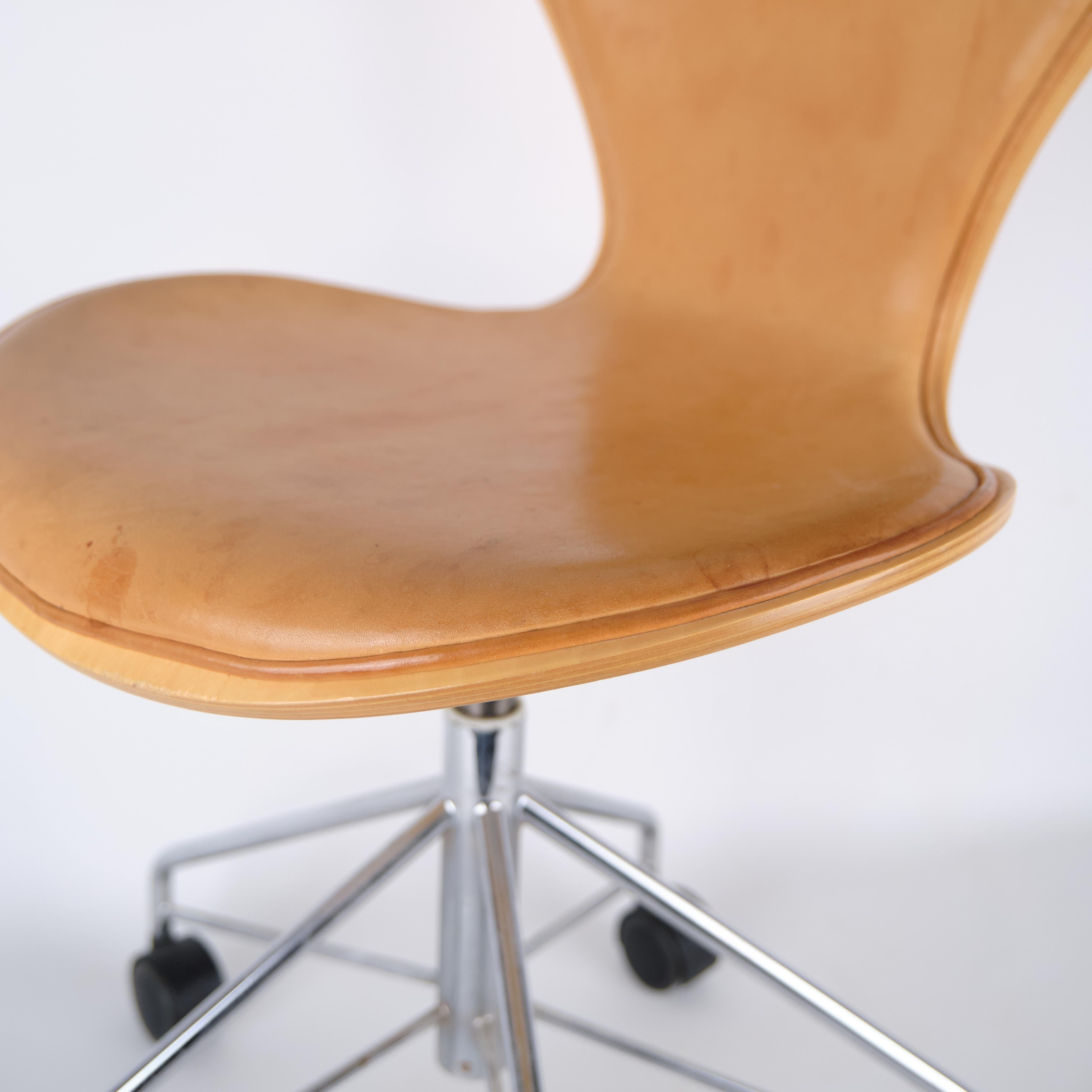 Arne Jacobsen seven office chair, model 3117, for Fritz Hansen. Patinated natural leather and chrome frame with wheels. Classic Danish design.

— Origin: Denmark
— Designer: Arne Jacobsen
— Manufacturer: Fritz Hansen
— Model: 3117 (Seven office