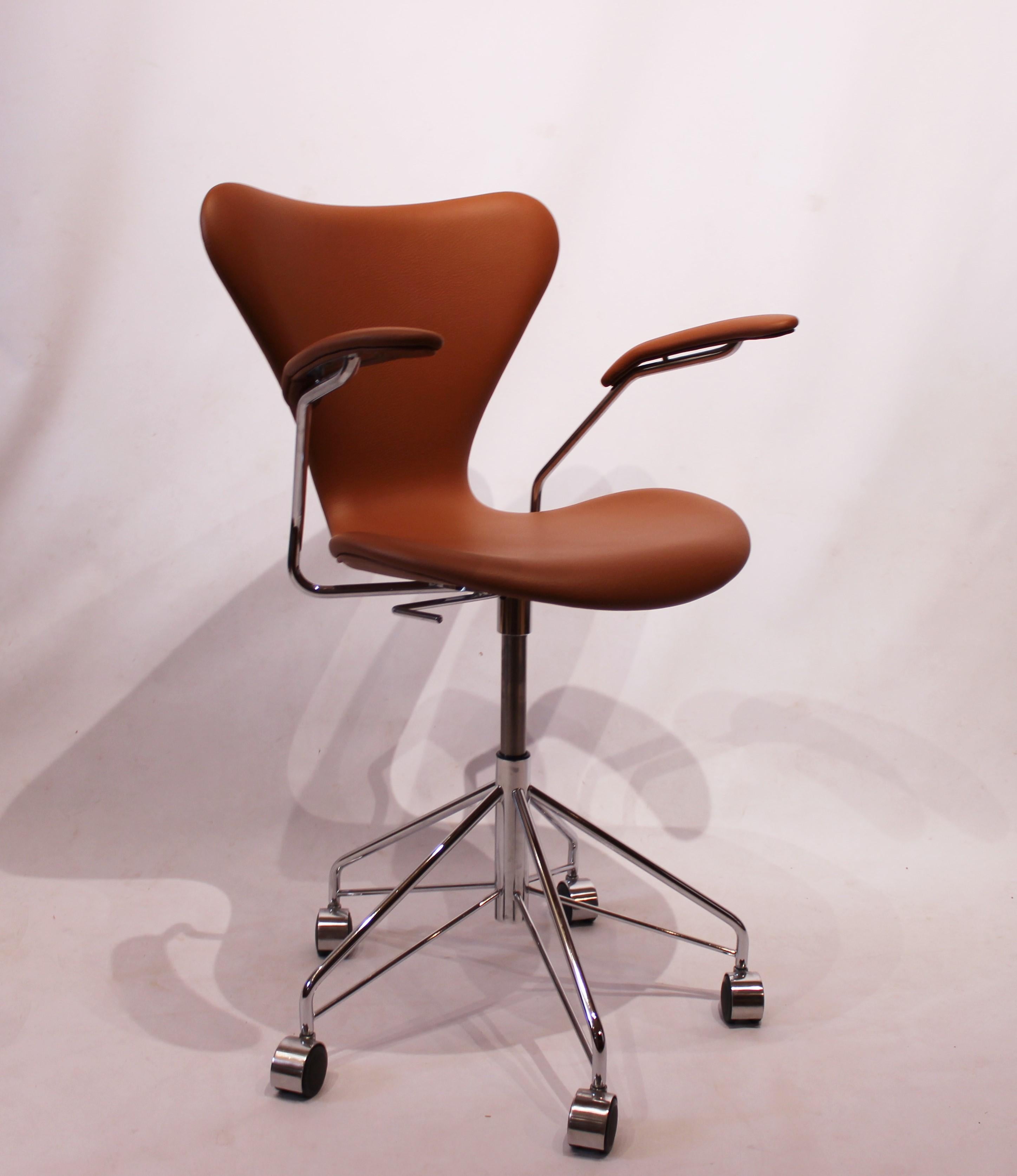 Seven office chair, model 3217, in cognac Classic leather with armrests and swivel function. The chair was designed by Arne Jacobsen in the 1950s and manufactured by Fritz Hansen. The item is in great vintage condition.