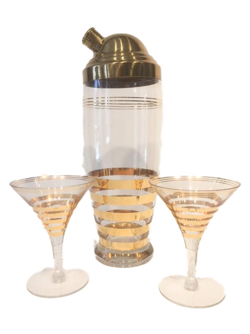 Seven piece Art Deco cocktail / martini set having gold bands on clear glass. The cocktail shaker has a domed gold-tone lid and the glasses are of classic martini glass form with gold banded bowls. All in excellent condition.


Cocktail shaker: