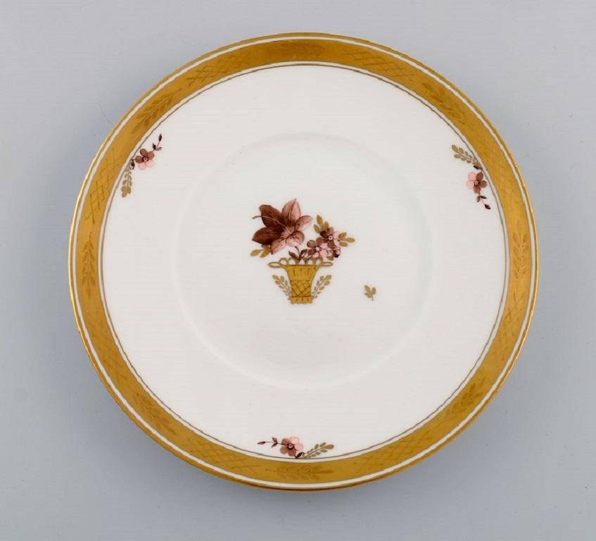 Seven Royal Copenhagen Golden Basket porcelain lunch plates with flowers and gold decoration. 
Model number 595/10521.
Diameter: 19.5 cm.
In excellent condition.
Stamped.
1st factory quality.