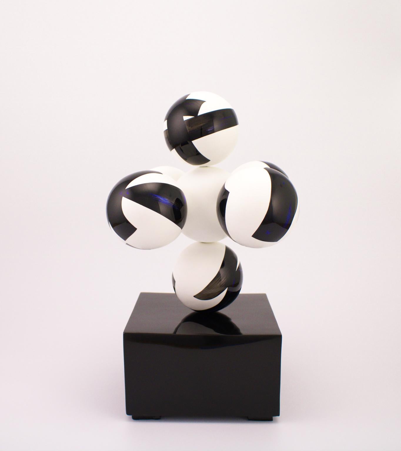 Sculpture in lacquered ceramics by Golem, seven white spheres with black and ultramarine blue decorations mounted in a criss cross pattern, black rectangular lacquered base. The white portions are opaque while all others are glossy to enhance