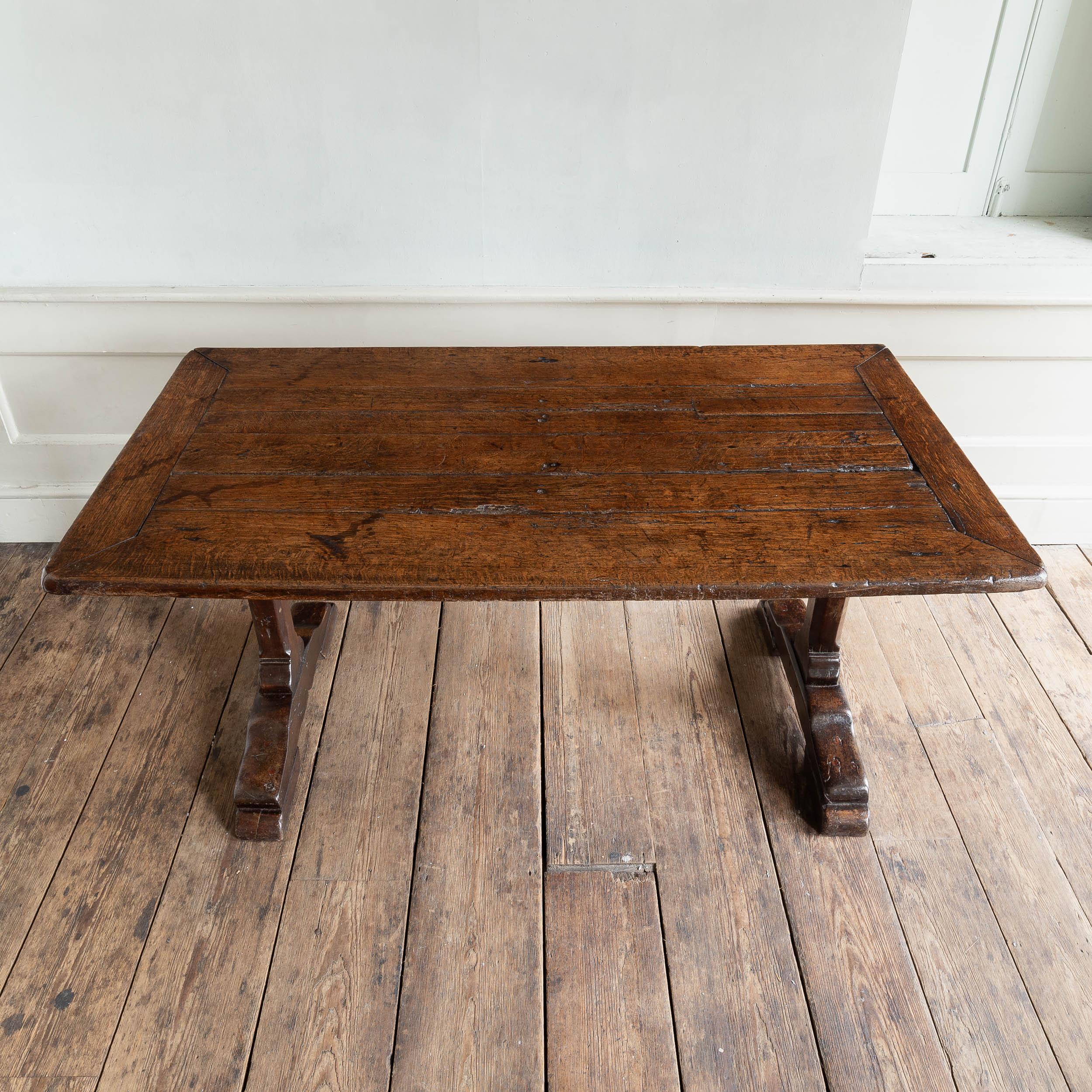 A joined oak trestle table, English, late seventeenth century,
the framed top with patch repairs, the whole attractively patinated throughout and of good medium oak colour, supplied with sympathetically conceived later extensions. Similar examples