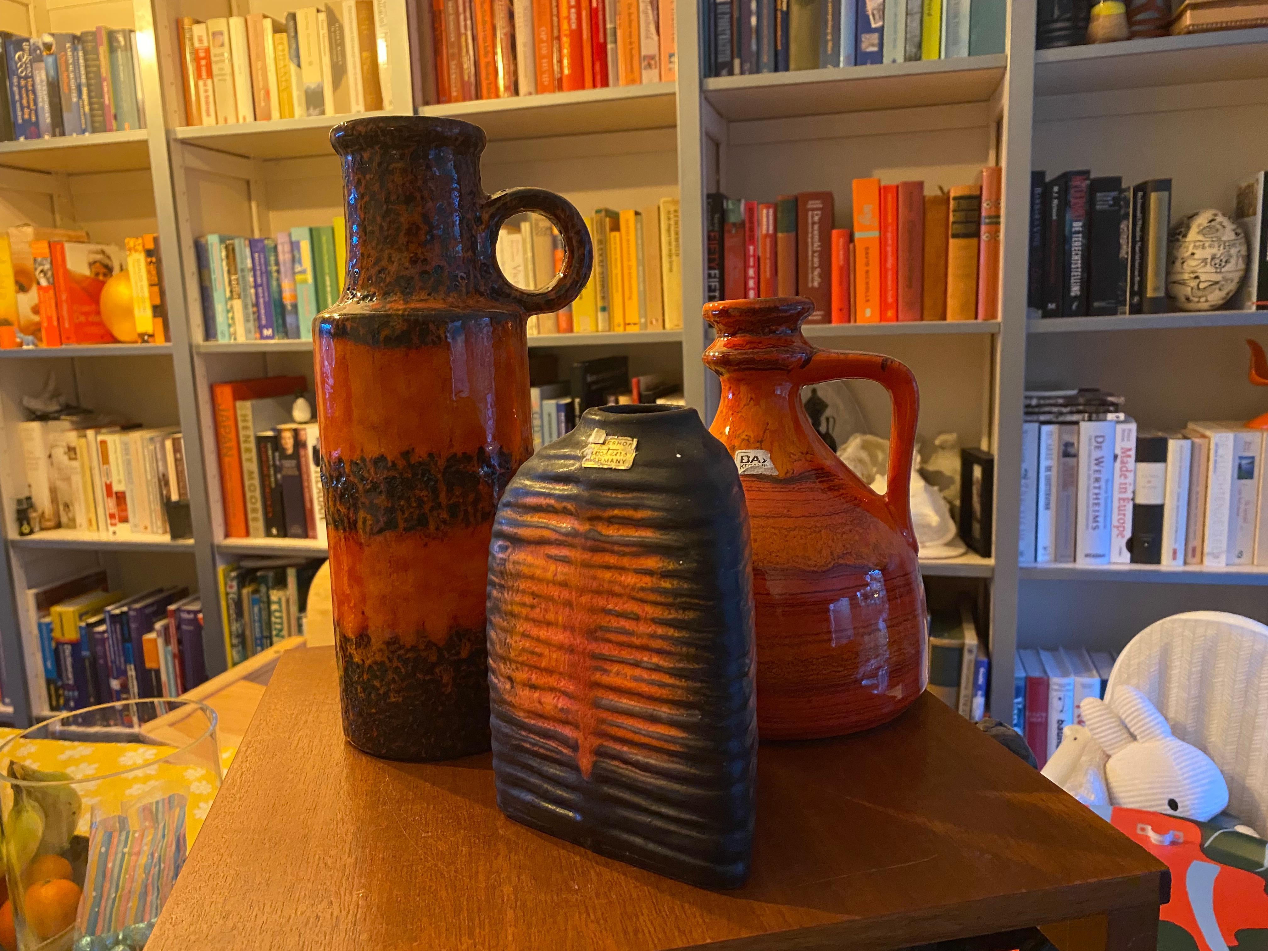 Three vibrant colored vases.
The highest vase is from Scheurich Keramik and the height is 28 cm

The orange vase is from Bay Keramik and its height is 20 cm

The triangle vase is from Carstens Tonnieshof Keramik and this one is 17 cm