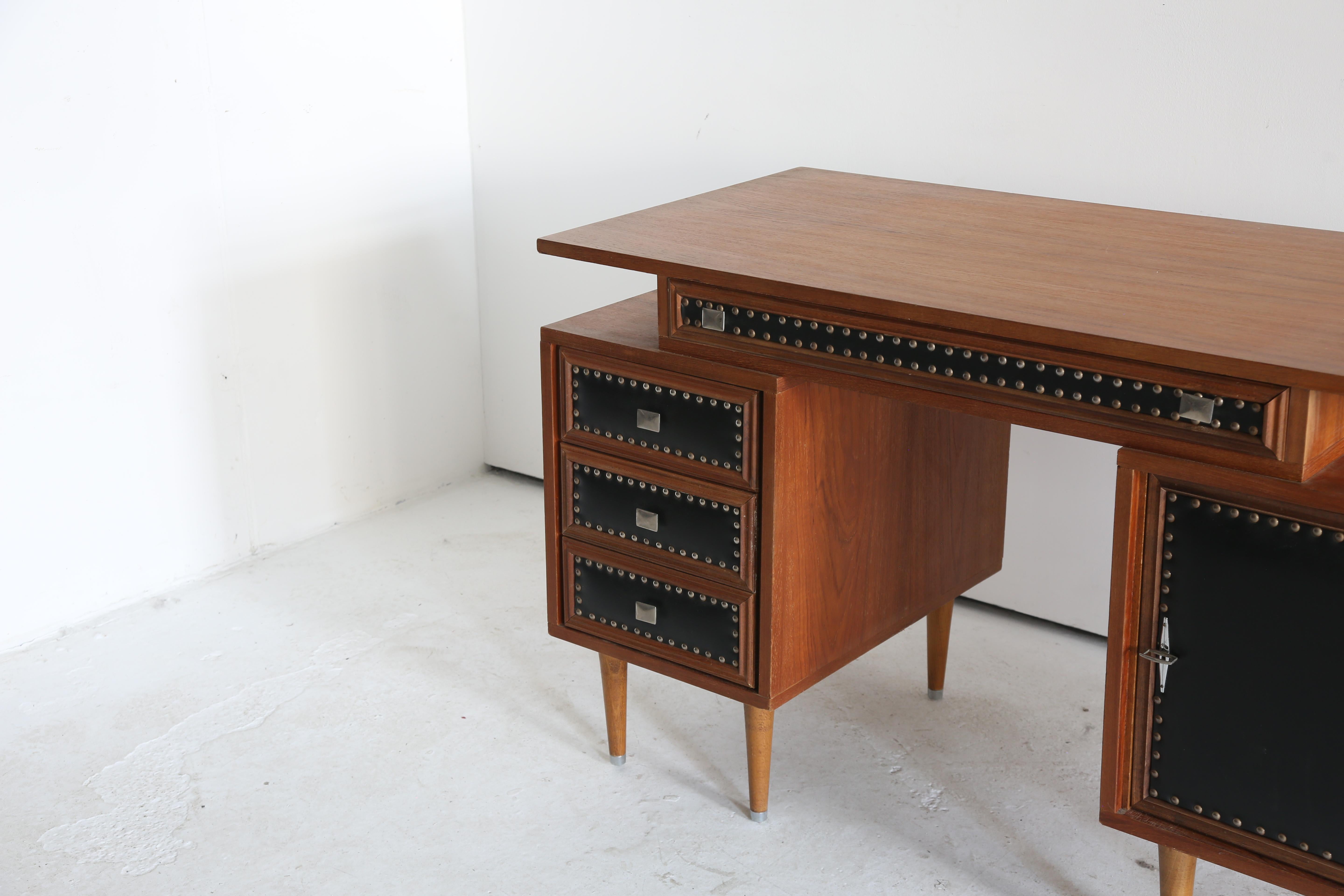 Outstanding studded detail teak desk.

An almost architectural feel to the proportions and construction.

Some light marking in places as to be expected, see photos.

France 1970s

L 120 cm x H 77 cm x D 61 cm