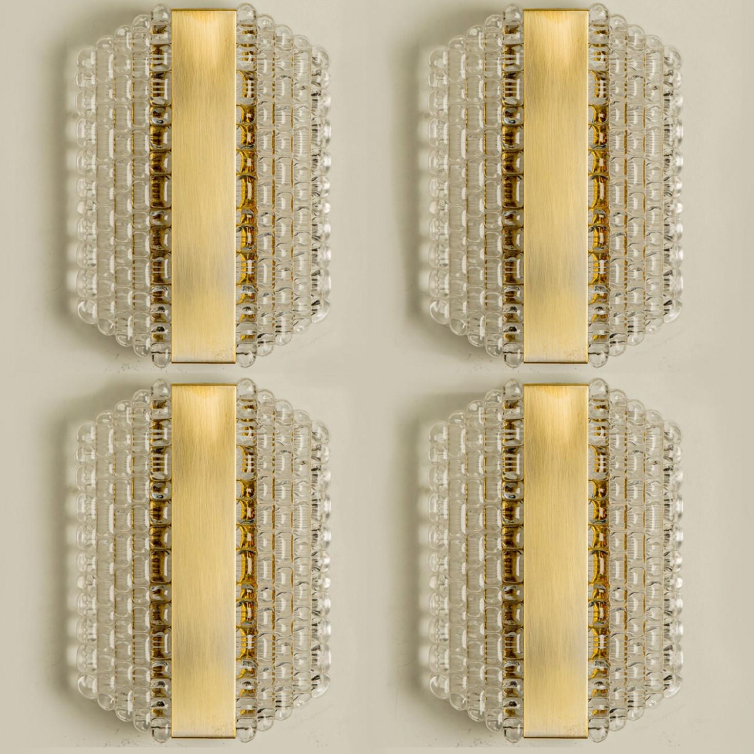 Several thick textured glass wall lights with a grid pattern, designed in Germany around the 1960s. These messing wall lights are handcrafted and of high quality.

Illuminates beautifully. The timeless elegance of wall light is sure to lend a