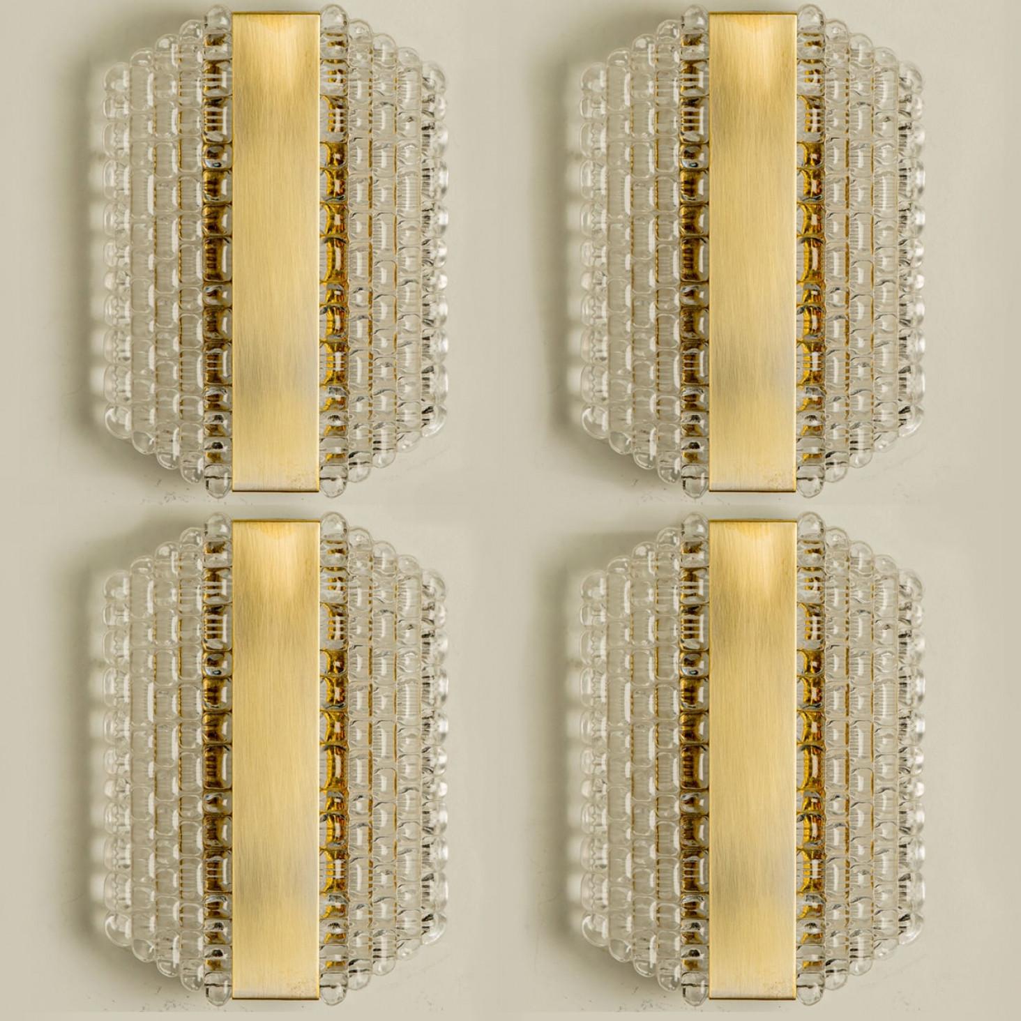 Varios apliques de cristal grueso texturizado con motivo de rejilla, diseñados en Alemania en torno a la década de 1960. Estos apliques desordenados están hechos a mano y son de gran calidad.

Ilumina maravillosamente. La elegancia atemporal de los