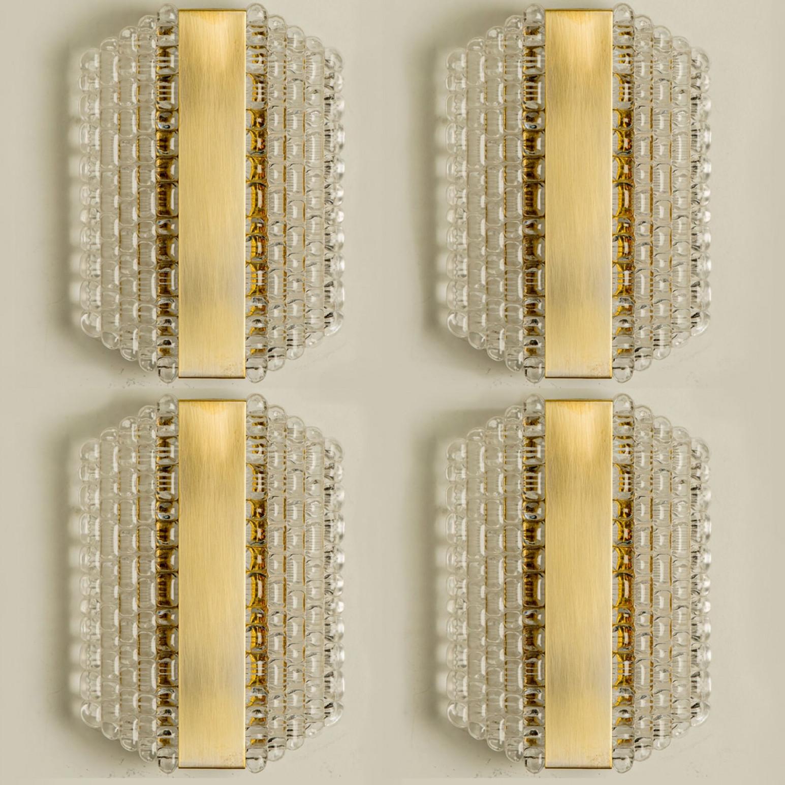 Mehrere Wandleuchten aus dickem, strukturiertem Glas mit Gittermuster, entworfen in Deutschland in den 1960er Jahren. Diese Messing-Wandleuchten sind handgefertigt und von hoher Qualität.

Leuchtet wunderschön. Die zeitlose Eleganz der Wandleuchte