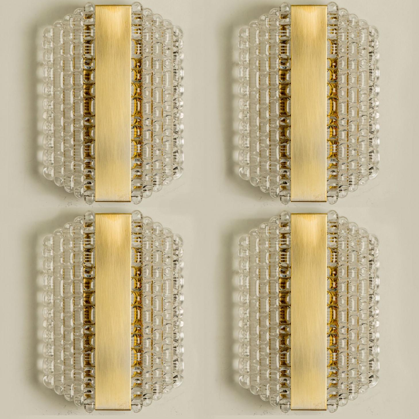 Mehrere Wandleuchten aus dickem, strukturiertem Glas mit Gittermuster, entworfen in Deutschland in den 1960er Jahren. Diese Messing-Wandleuchten sind handgefertigt und von hoher Qualität.

Leuchtet wunderschön. Die zeitlose Eleganz der Wandleuchte