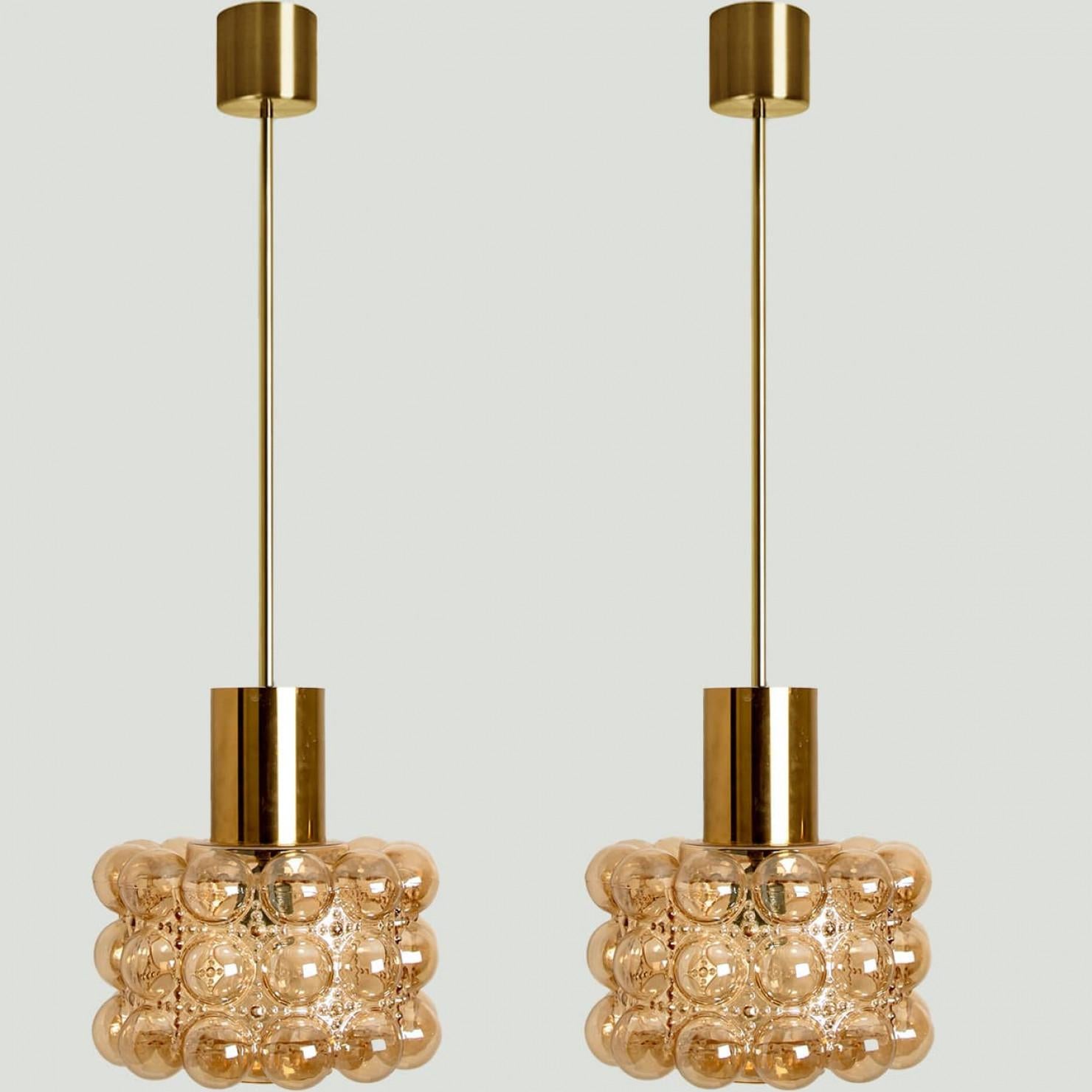 Varias arañas o lámparas colgantes de cristal burbuja diseñadas por Helena Tynell para Glashütte Limburg. Un clásico del diseño, el vidrio soplado a mano proporciona un maravilloso resplandor cálido.

Las dimensiones: Altura 80 cm desde el techo, el