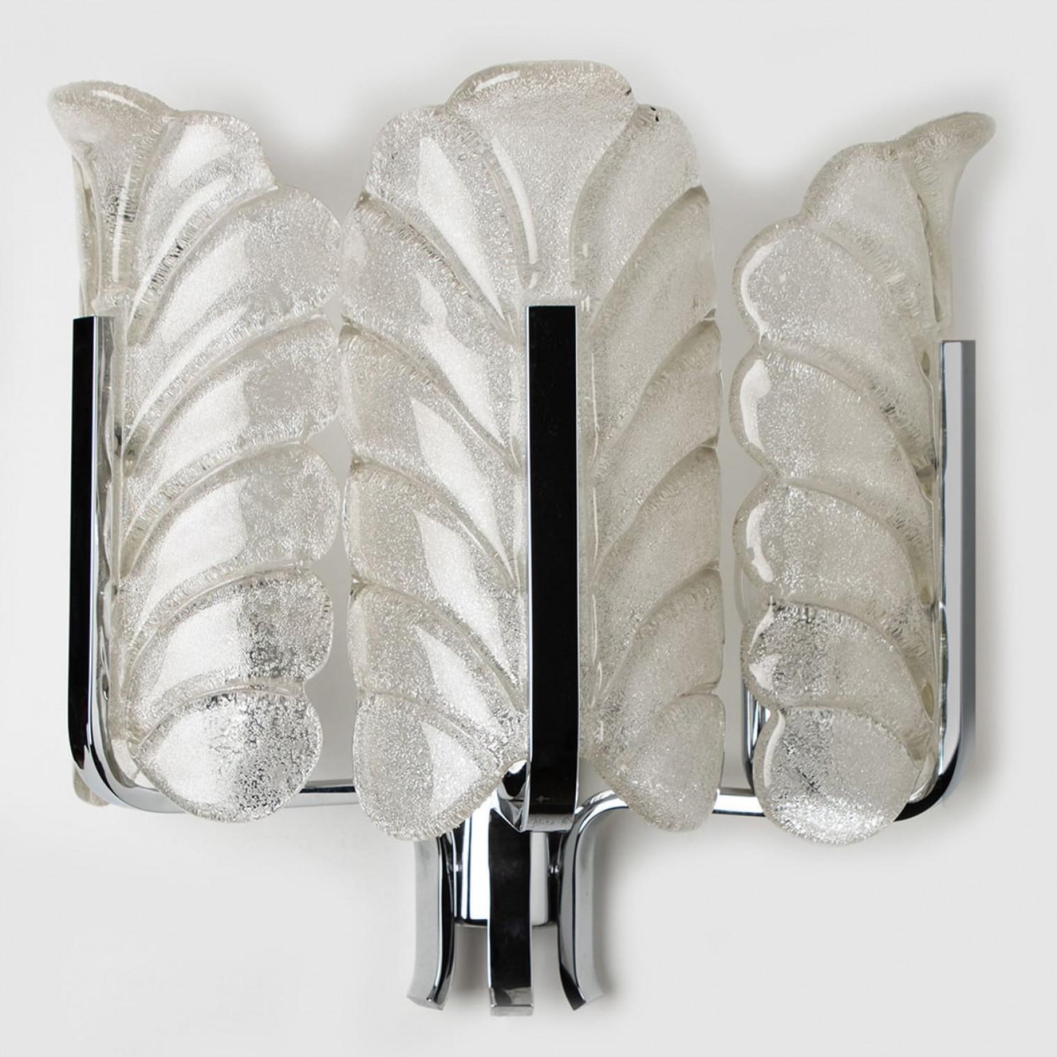 Questa bellissima applique con tre paralumi in vetro e base cromata è stata prodotta negli anni '60 dall'iconica azienda Orrefors e disegnata da Carl Fagerlund. Paralumi in vetro smerigliato trasparente splendidamente intagliati con un design a