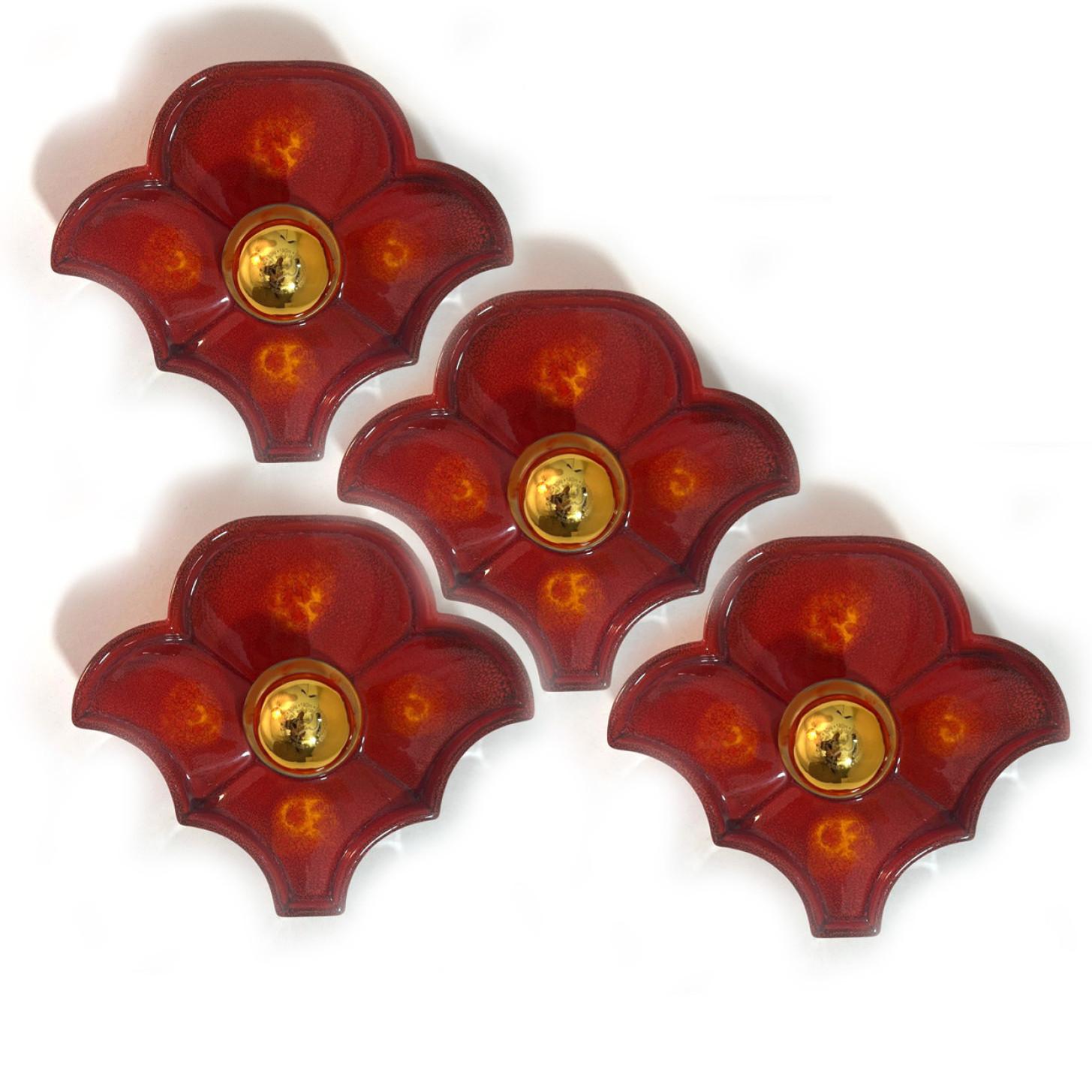 Red ceramic wall lights. Manufactured by Hustadt Leuchten Keramik, Germany in the 1970s.

The glaze is red coloured in a flower shape.

We used gold mirror light bulbs (see images), but silver mirror or soft gold light bulbs are also very