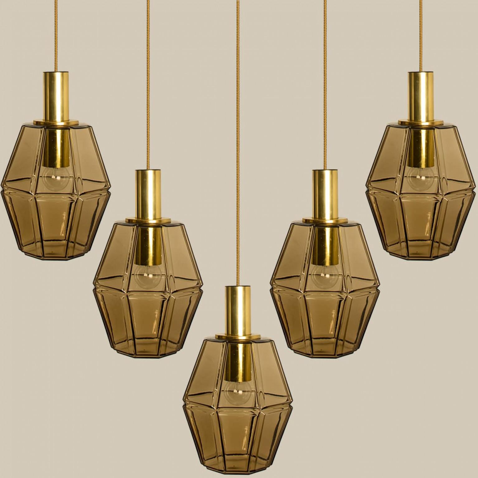 Diverse lampade a sospensione geometriche in ottone e vetro di Limburg, anni '70.

Bellissima lampada minimalista, dalle linee pulite e dal design senza tempo.

Illumina meravigliosamente.

Il prezzo si riferisce a un solo pezzo, ma ne abbiamo