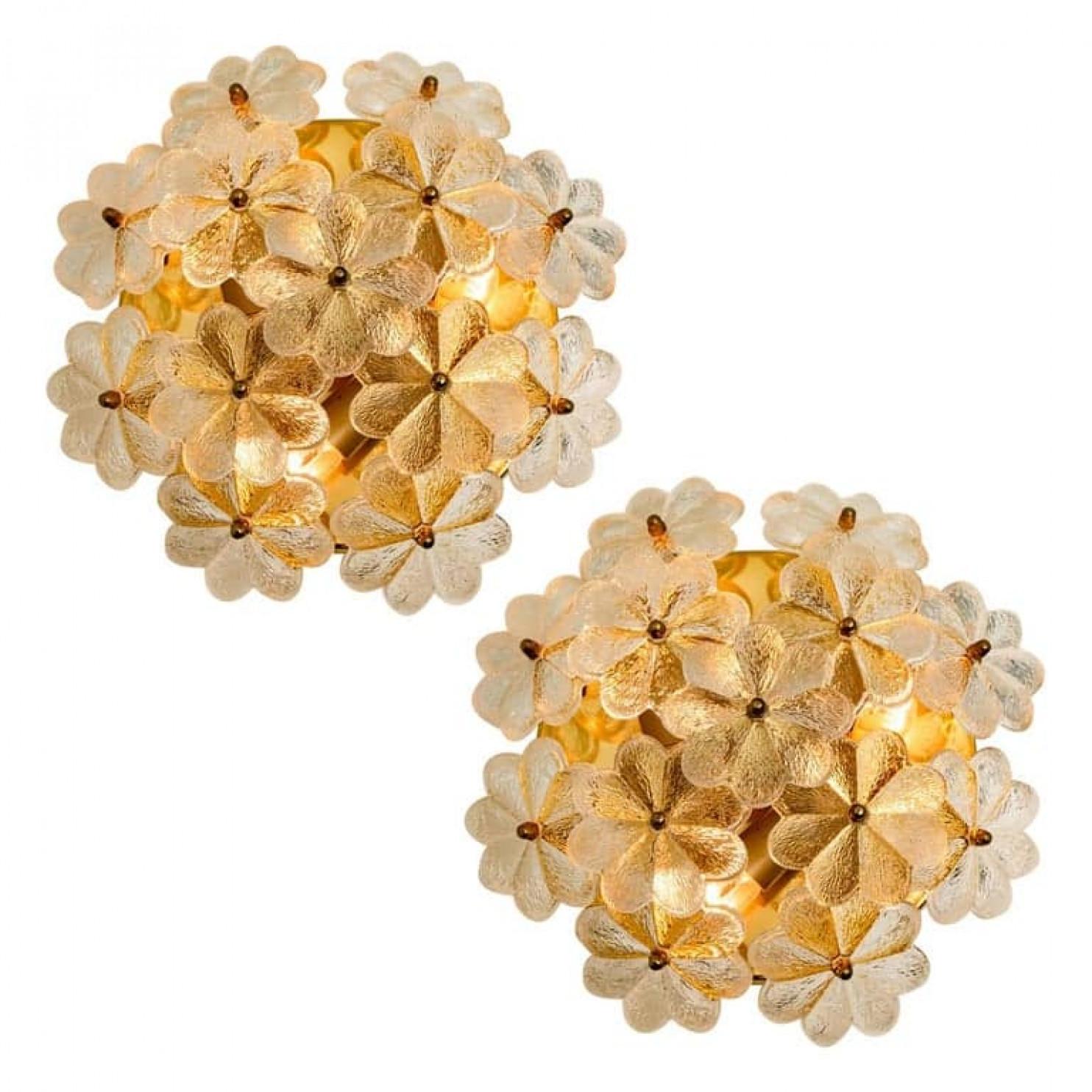 Large sculptural wall sconces have the design of a bouquet of textured glass flowers and are from the historical lighting company Ernst Palme. Each clear glass flower shade has textured petals and is securely screwed in place to the frame with a