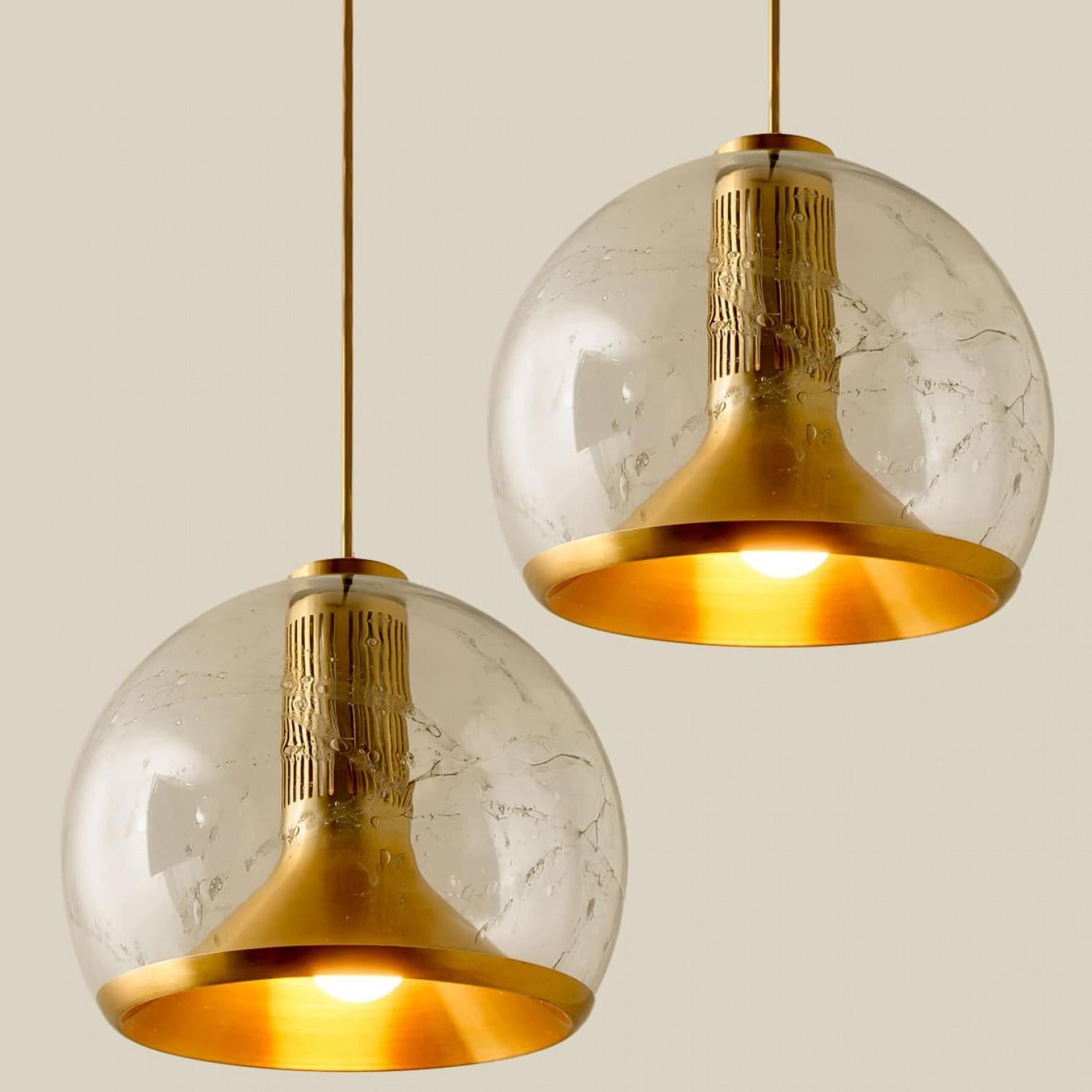 Plusieurs grands plafonniers en verre et en laiton des années 1970 de l'usine Doria Leuchten, Allemagne, Europe. La lampe est dotée d'un magnifique abat-jour en verre clair de qualité supérieure, d'un abat-jour intérieur en laiton et d'un raccord en
