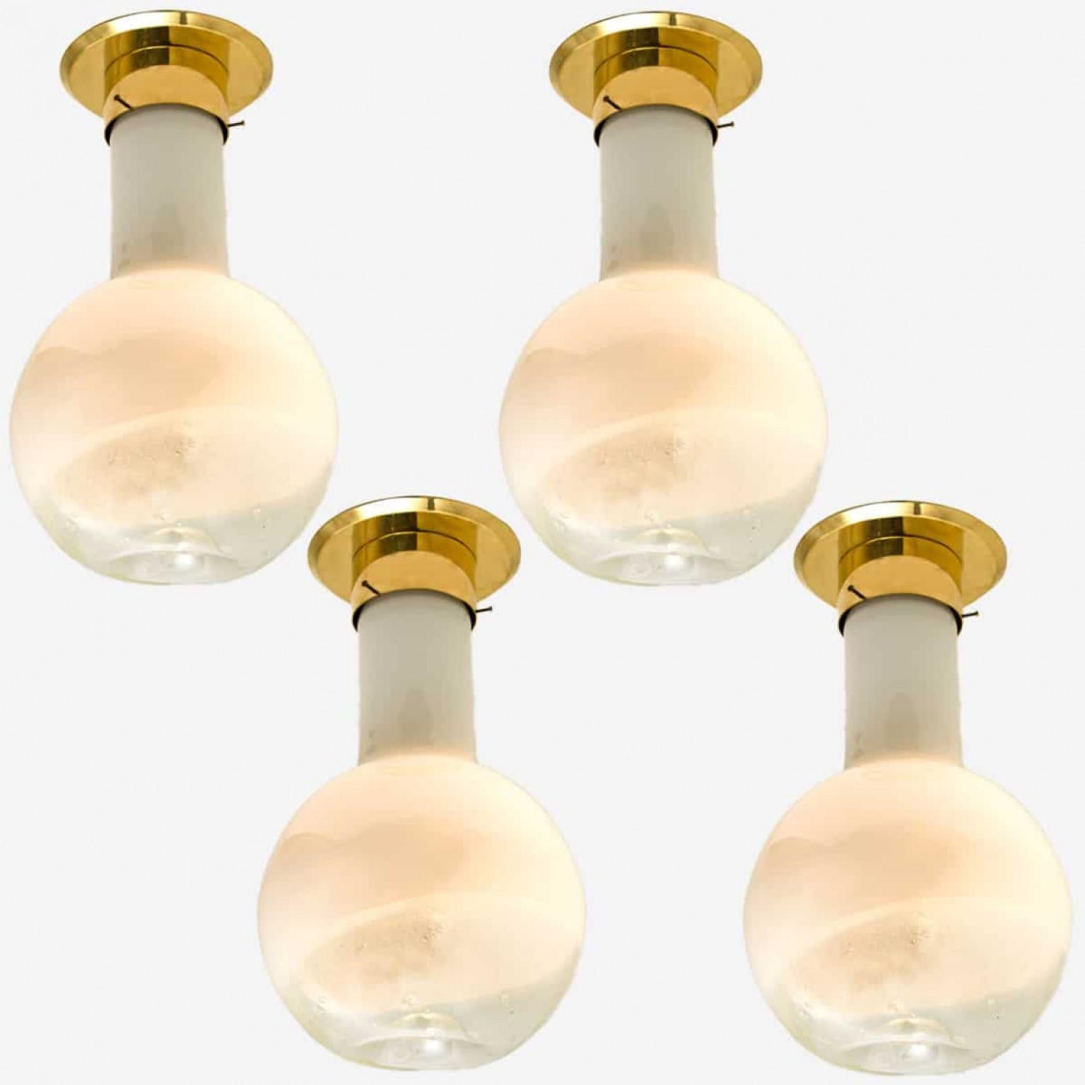 Queste bellissime lampade da soffitto di grandi dimensioni in vetro con dettagli in ottone sono state prodotte da Harrachov nella Repubblica Ceca intorno al 1970.

Le lampade hanno una bella forma, metà cilindro e metà rotonda. Questo crea un