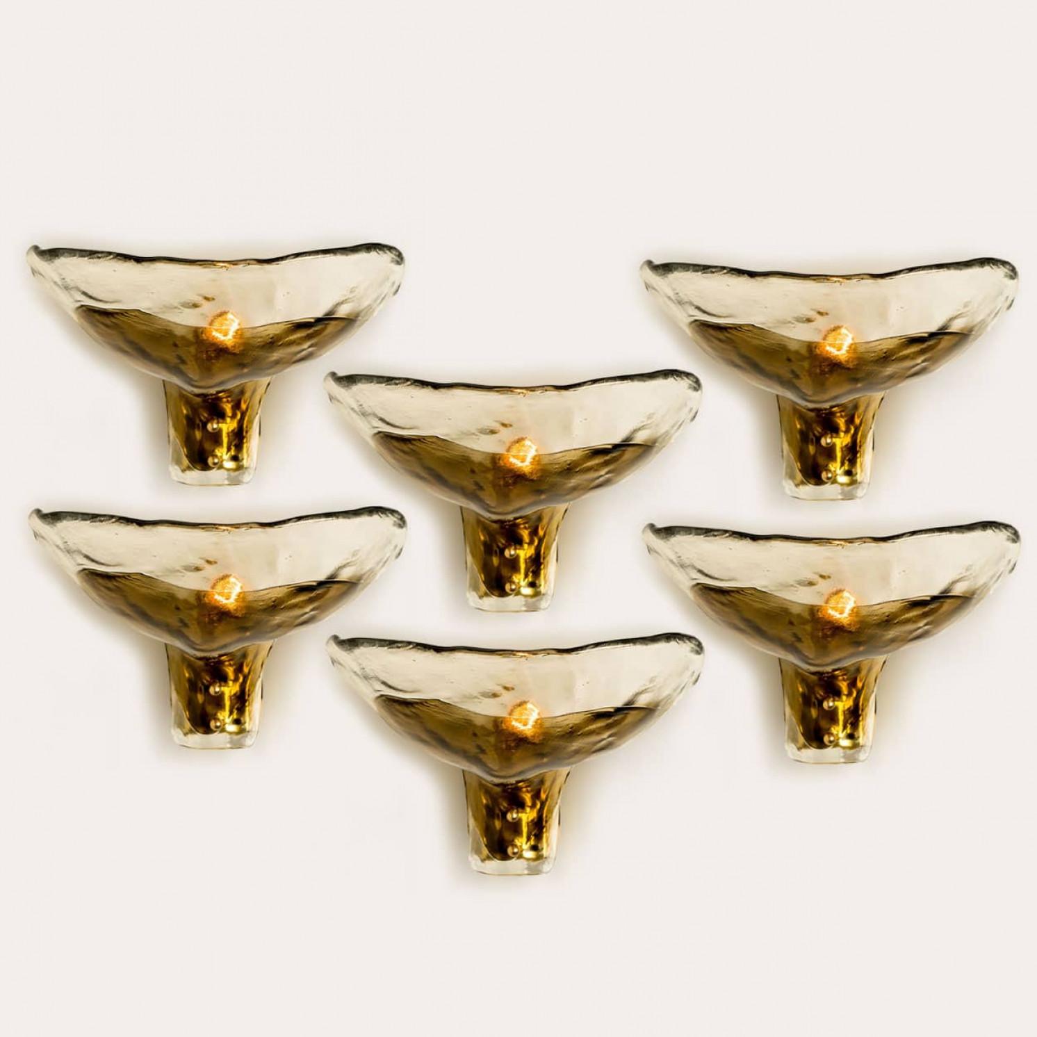 Several Smoked glass wall lamps from the 1960s. Spectaculair  design and  high quality workmanship.
The light illuminates lovely due to the  smoked and structured glass and brass, it creates a spectacular play of light.

In excellent vintage