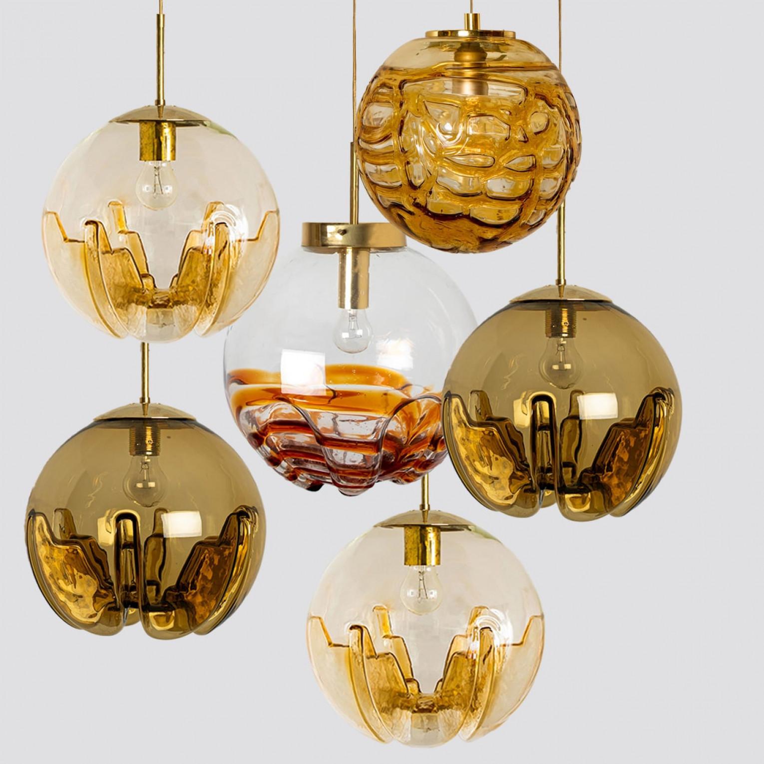 Una colección de preciosas y elegantes lámparas colgantes de cristal fabricadas en Alemania e Italia en torno a la década de 1960. La lámpara Doria es de cristal amarillo transparente en forma de burbuja. La luz Kaiser es de cristal transparente de