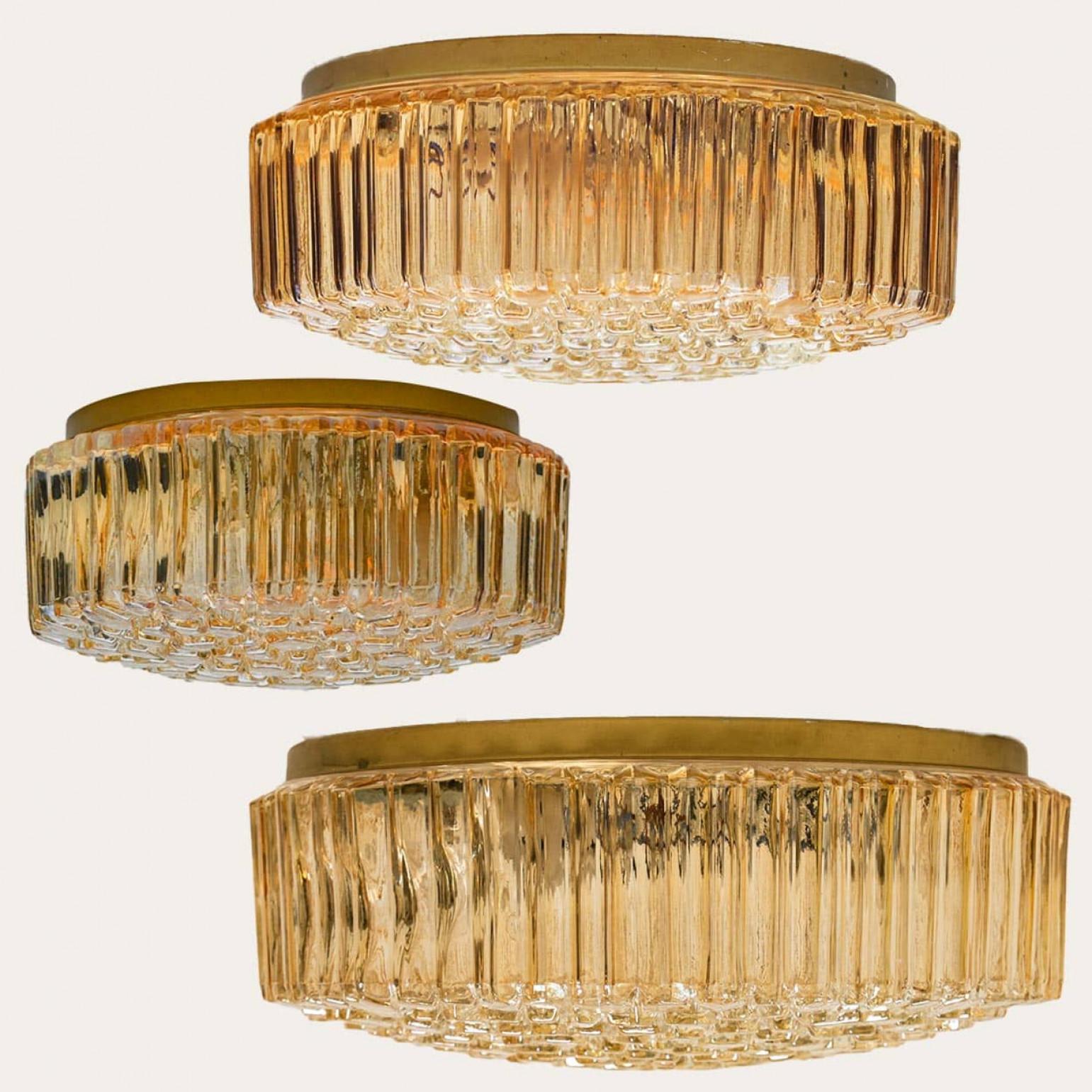 Satz von drei bernsteinfarbenen Wandleuchten aus strukturiertem Glas, entworfen von Glashütte Limburg um 1960-1970 in Europa, Deutschland. Das reich strukturierte, blasige Glas gibt einen wunderbaren Glanz.

Kann als Wandleuchte oder als