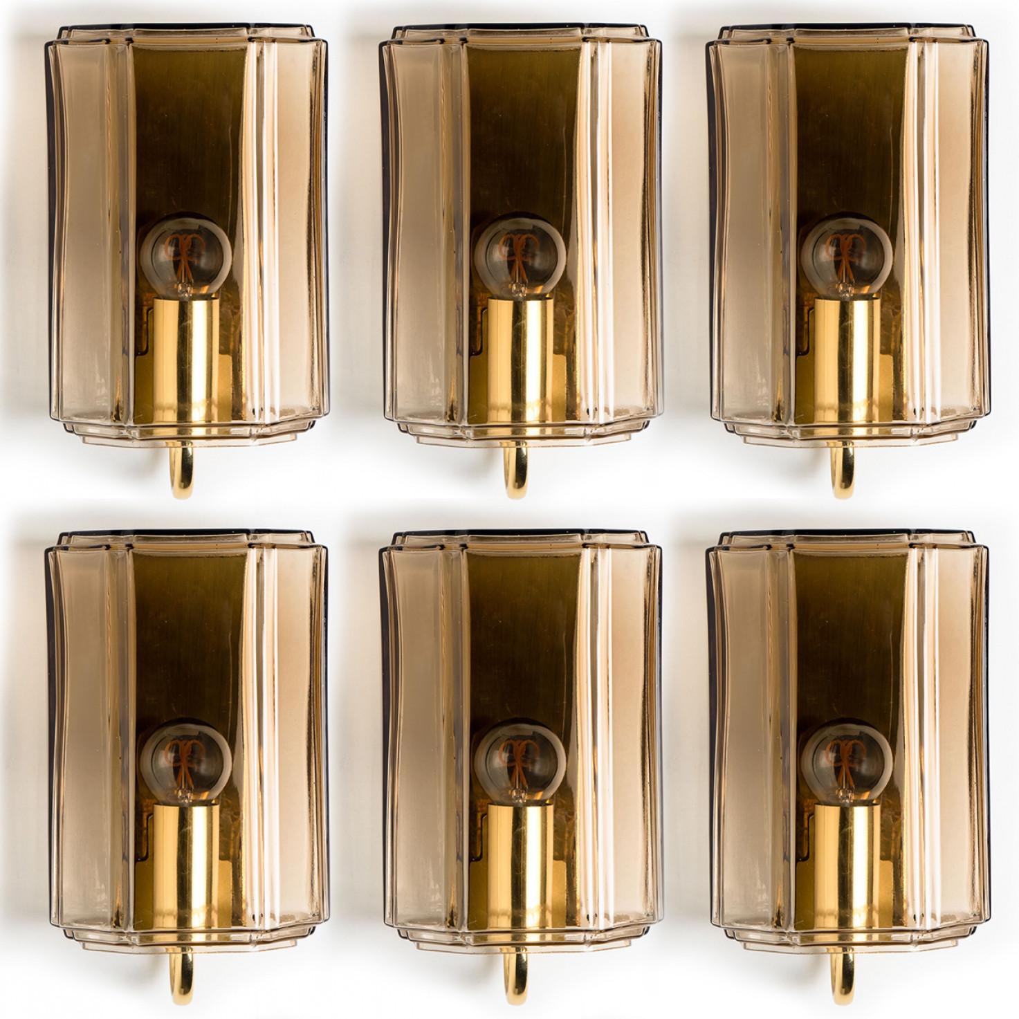 These beautiful hand blown glass wall lights were manufactured by Glashütte Limburg in Germany during the 1960s (late 1960s-early 1970s). Beautiful craftsmanship. These mid century vintage lights feature handmade, elaborate smoked glass with brass