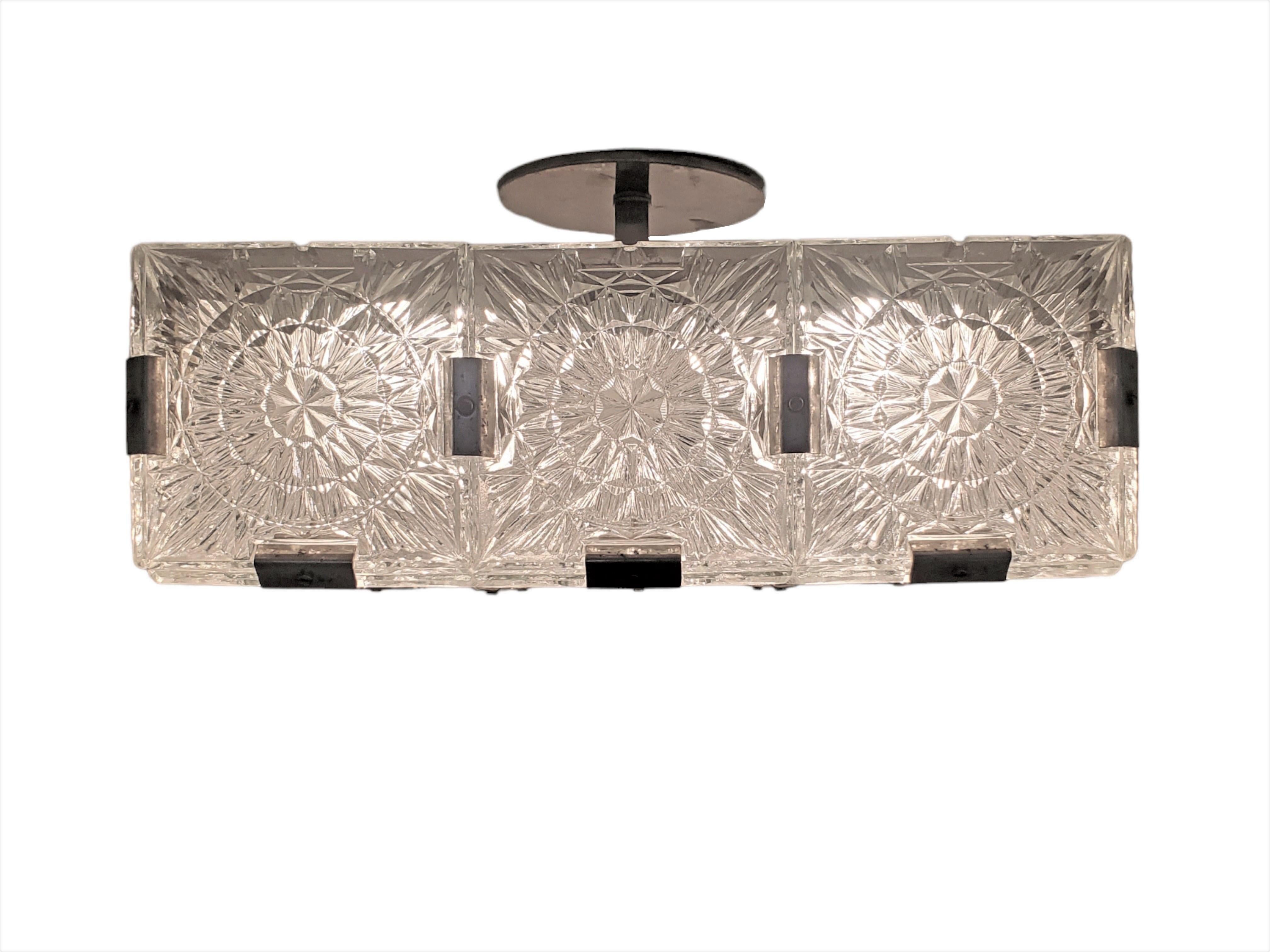 One of several Mid-Century Modern semi- flush mounted ceiling squares.
Patterns of geometric and stylized floral motif decorate this lovely architecturally square chandelier in a gridwork of square glass panels structurally and decoratively