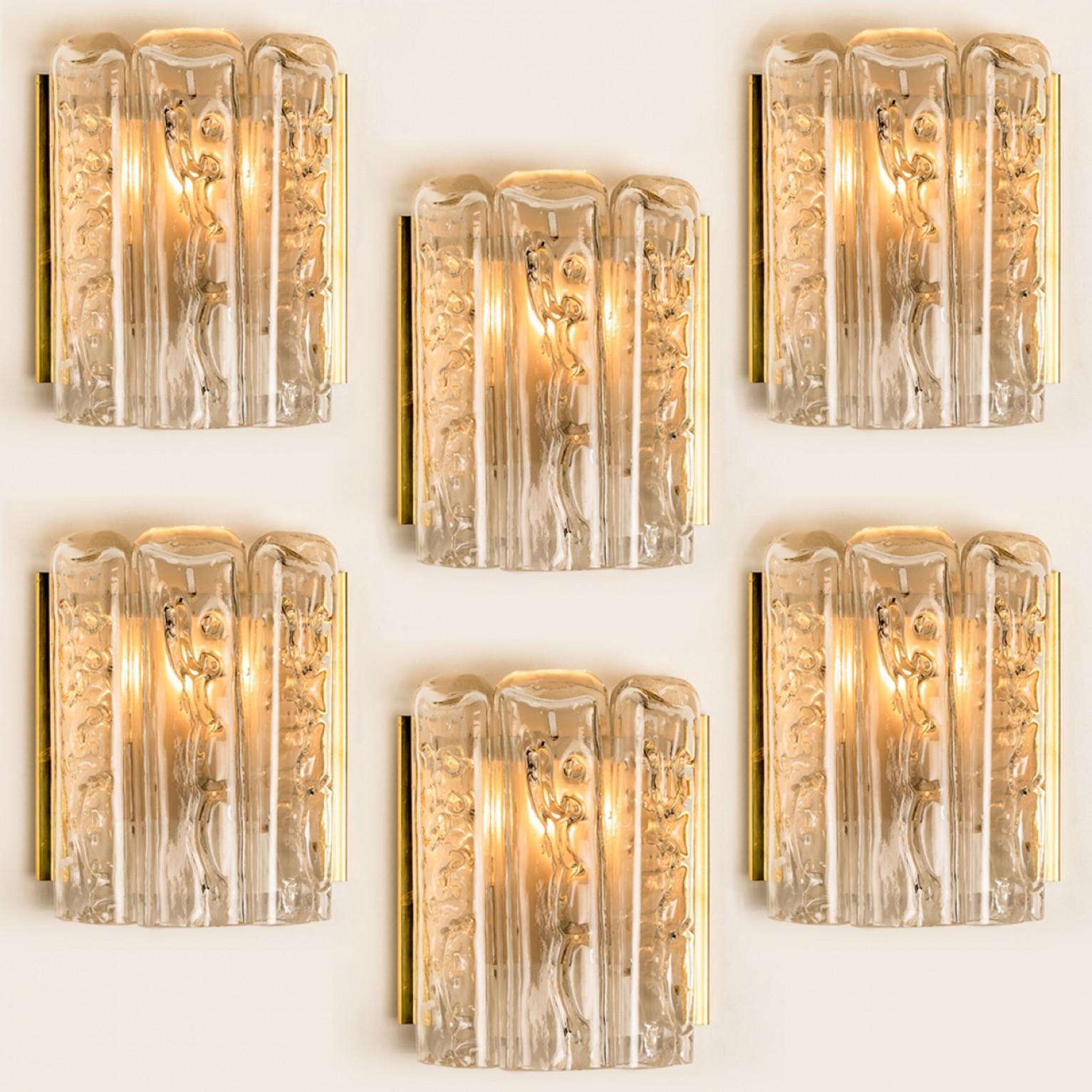 This set of blown wall sconces date from the 1960s and were created by the iconic firm of Doria Leuchten in Germany. They are fabricated with a back plate in white and brass and with two molten-glass, flat tubular prisms. High-end pieces

Several