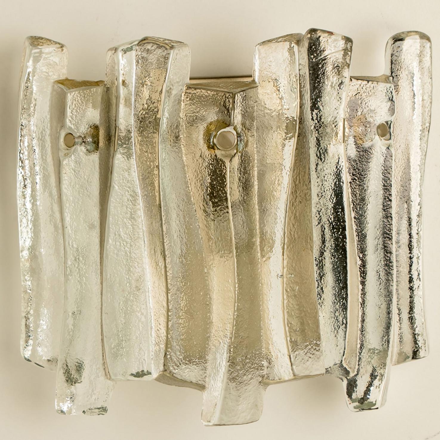Beautiful and elegant modern wall lights in the style of Kalmar in the 1970s. A lovely design. Nine thick, textured glass beams in an organic, wave-like shape. The clear glass has an icy, handcrafted look, creating a sculptural and elegant effect.