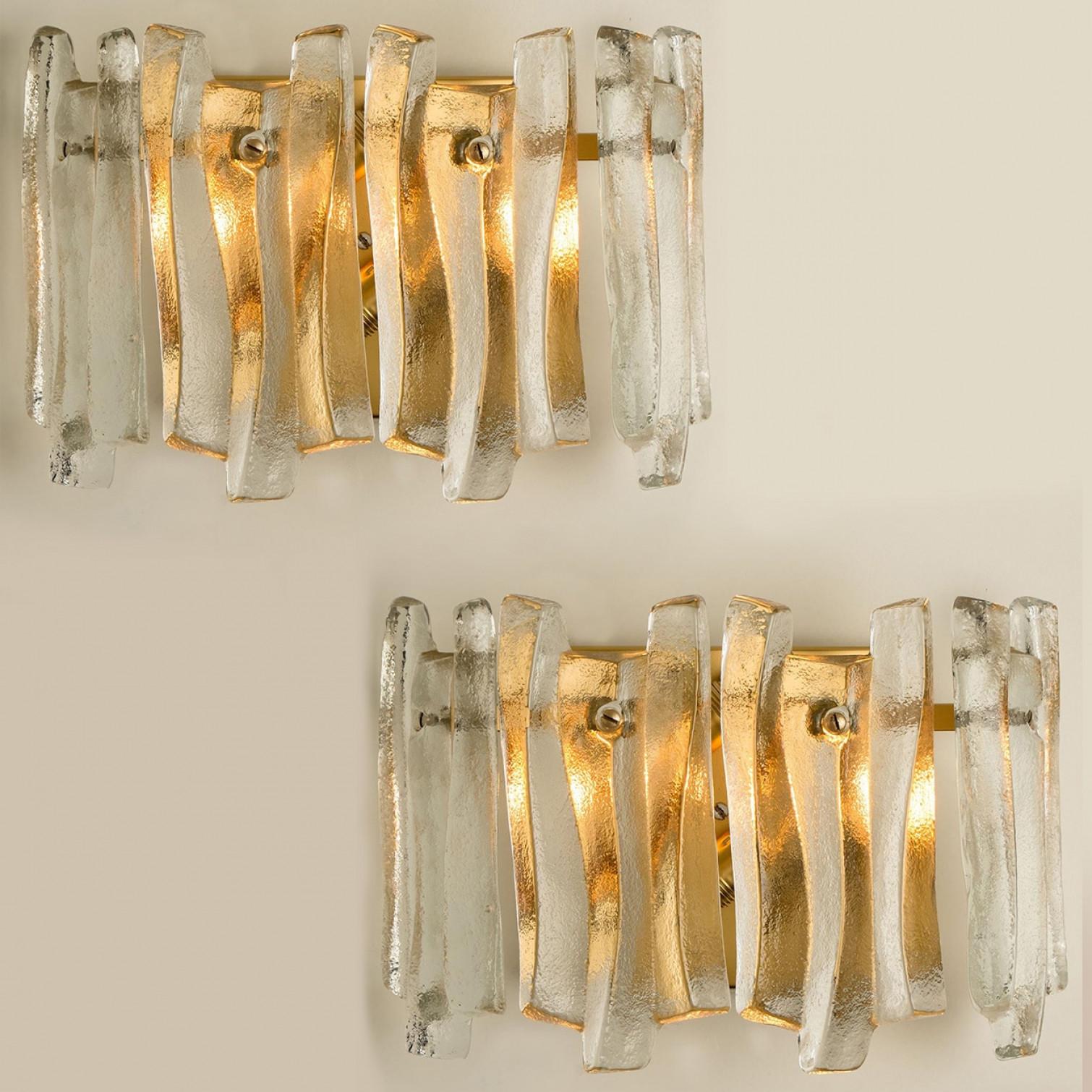 Bellissime ed eleganti applique moderne nello stile di Kalmar degli anni '70. Un design incantevole. Dodici travi di vetro spesse e strutturate in una forma organica e ondulata. Il vetro trasparente ha un aspetto gelido e artigianale, creando un