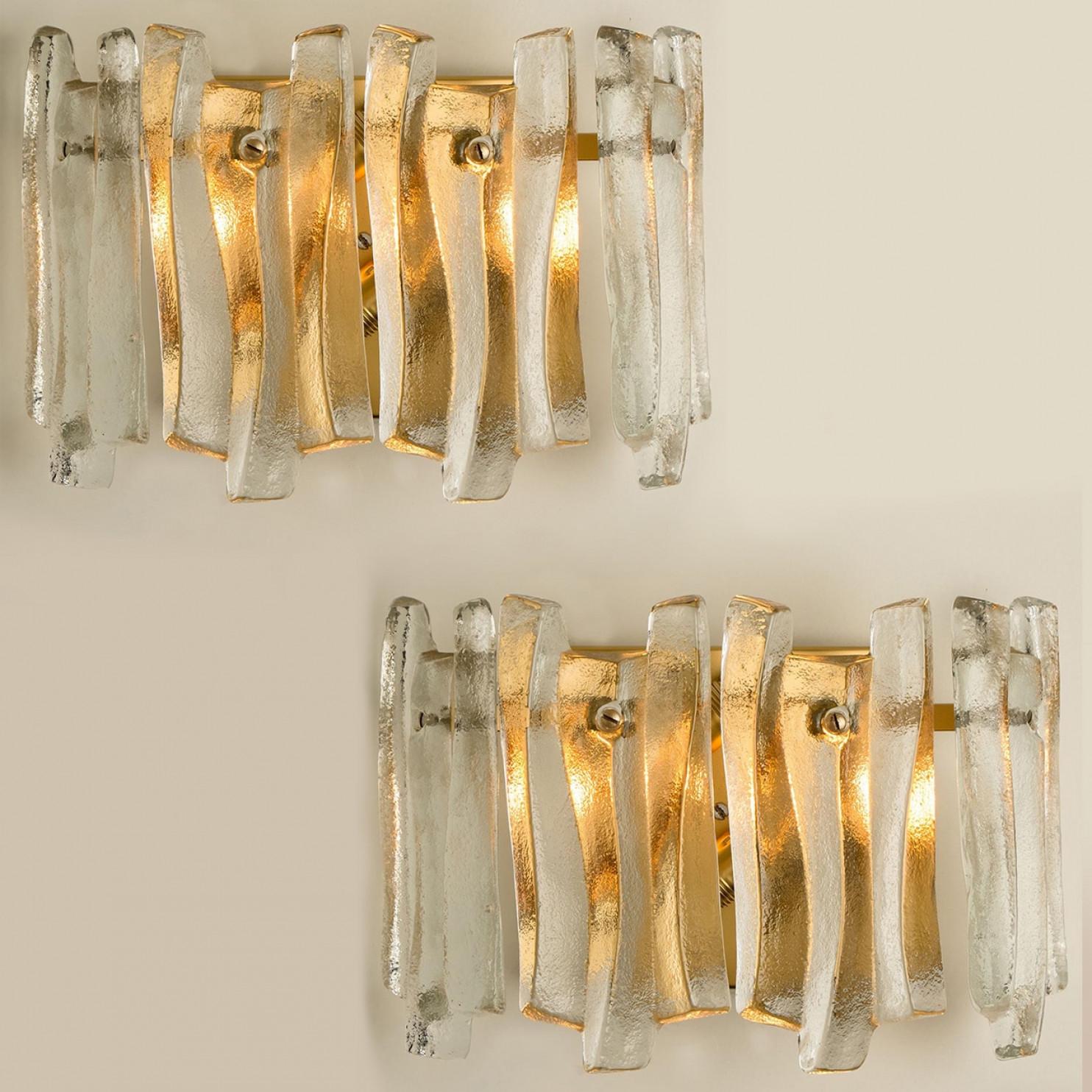 Preciosos y elegantes apliques modernos al estilo de Kalmar en la década de 1970. Un diseño precioso. Doce gruesas vigas de cristal texturizado en forma de onda orgánica. El cristal transparente tiene un aspecto helado y artesanal, creando un efecto