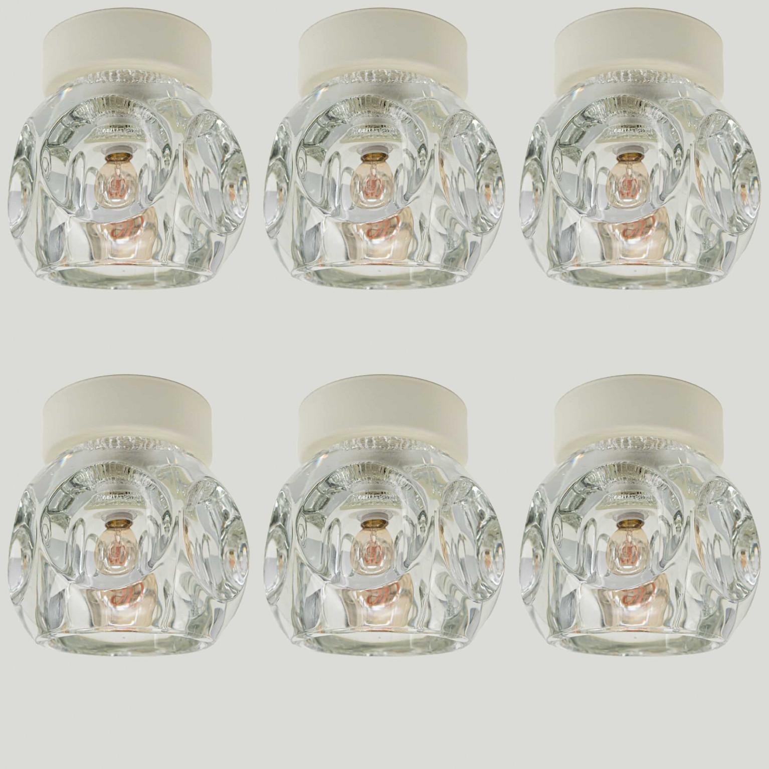 Ice Cube lamps impresses with wonderfully shiny glass and unique design from 1972. With warm off white back plate. Can used as wall or flush light.

The light cubes were manufactured by the renowned lamp manufacturer Peill and Putzler in Germany and