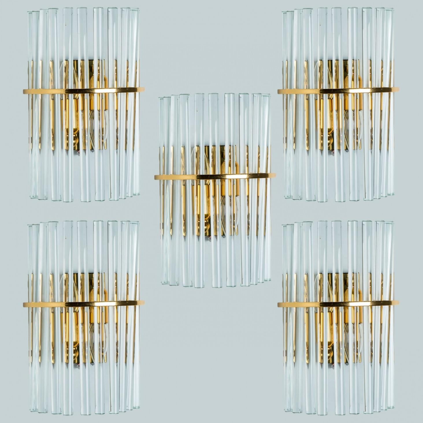 Preciosos apliques de pared de cristal de media caña con múltiples varillas largas en forma de tubo de cristal transparente, con detalles de latón y placa posterior. Ilumina maravillosamente. Piezas de alta gama.

Dimensiones:
Altura: 30 cm