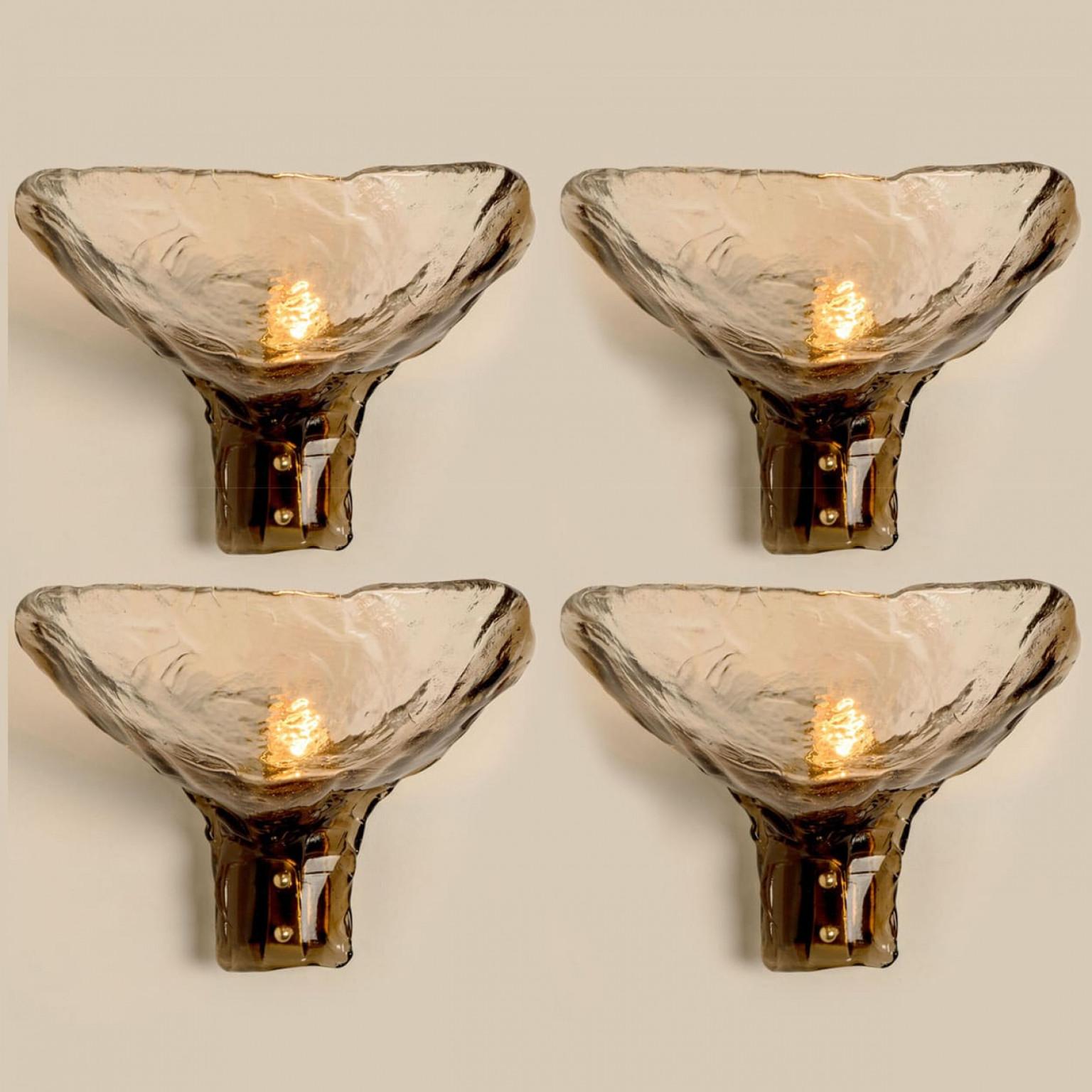 Diverse lampade da parete in vetro fumé degli anni '60. Design spettacolare e lavorazione di alta qualità.
La luce si illumina in modo delizioso grazie al vetro fumé e strutturato e all'ottone, creando uno spettacolare gioco di luci.

In ottime