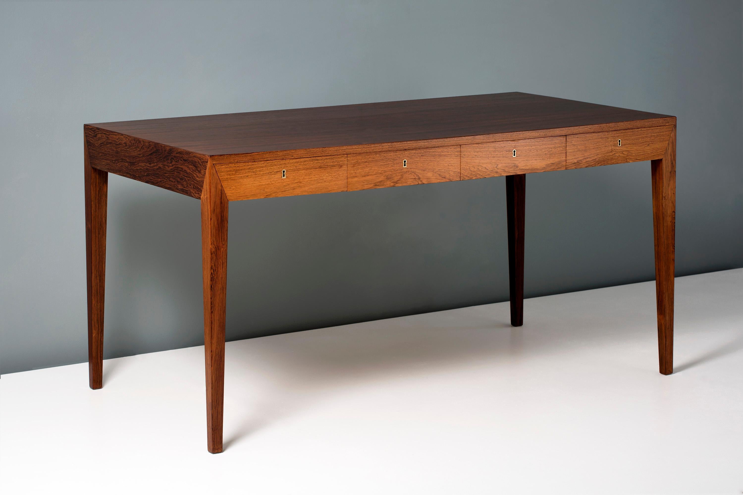Severin Hansen Jnr.

Writing desk, circa 1950s.

This iconic piece of Danish design was produced by Haslev Mobelsnedkeri in Denmark in the late 1950s. The desk is made from solid and veneered Brazilian rosewood with brass fittings in 4 integral