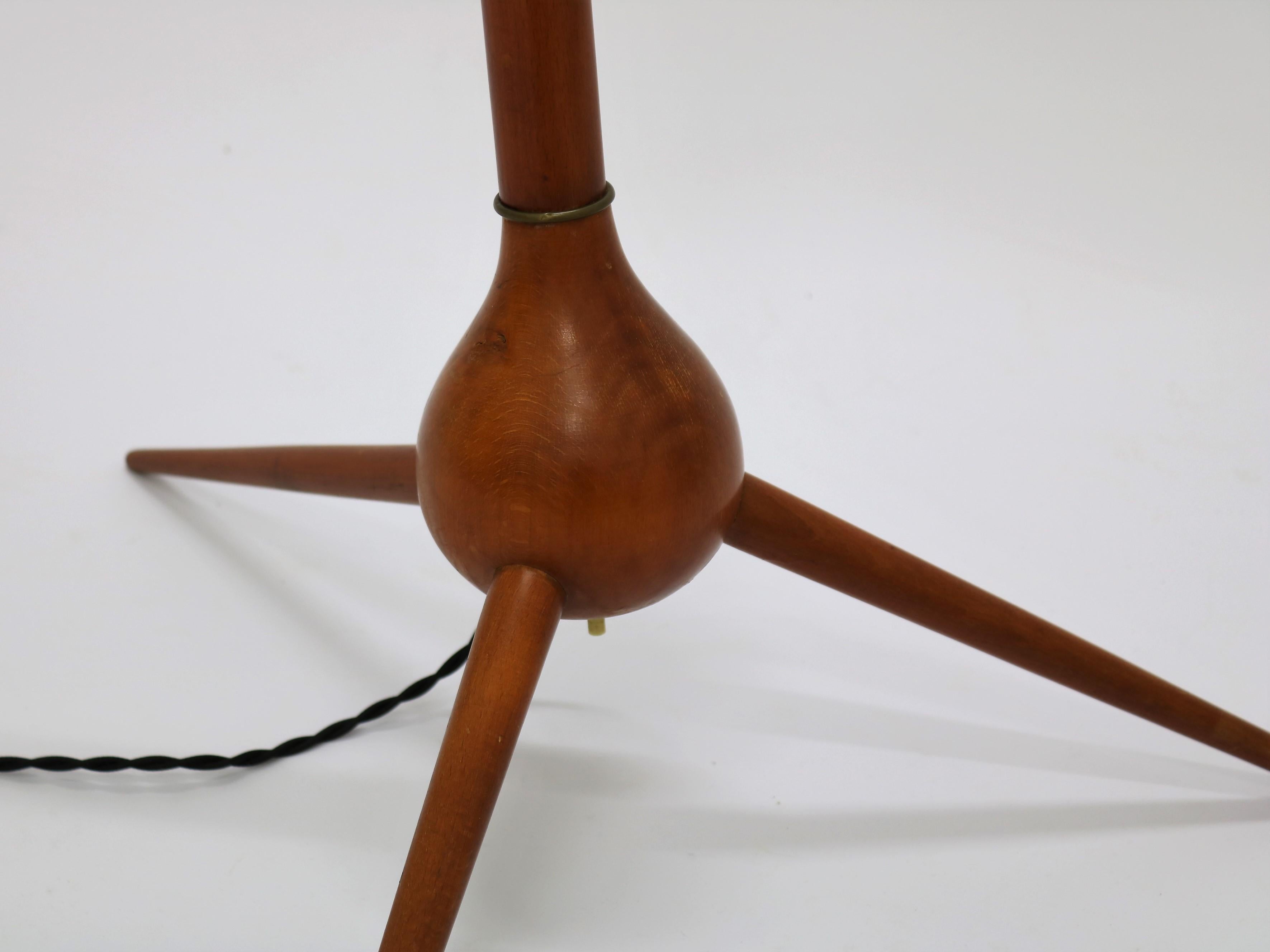 Floor lamp by Danish designer Severin Hansen for Haslev Furniture in the 1950s. The lamp base is made of stained beech with brass elements. The switch is placed between the elegant tripod legs and the lamp can be turned on by the foot. The shade is
