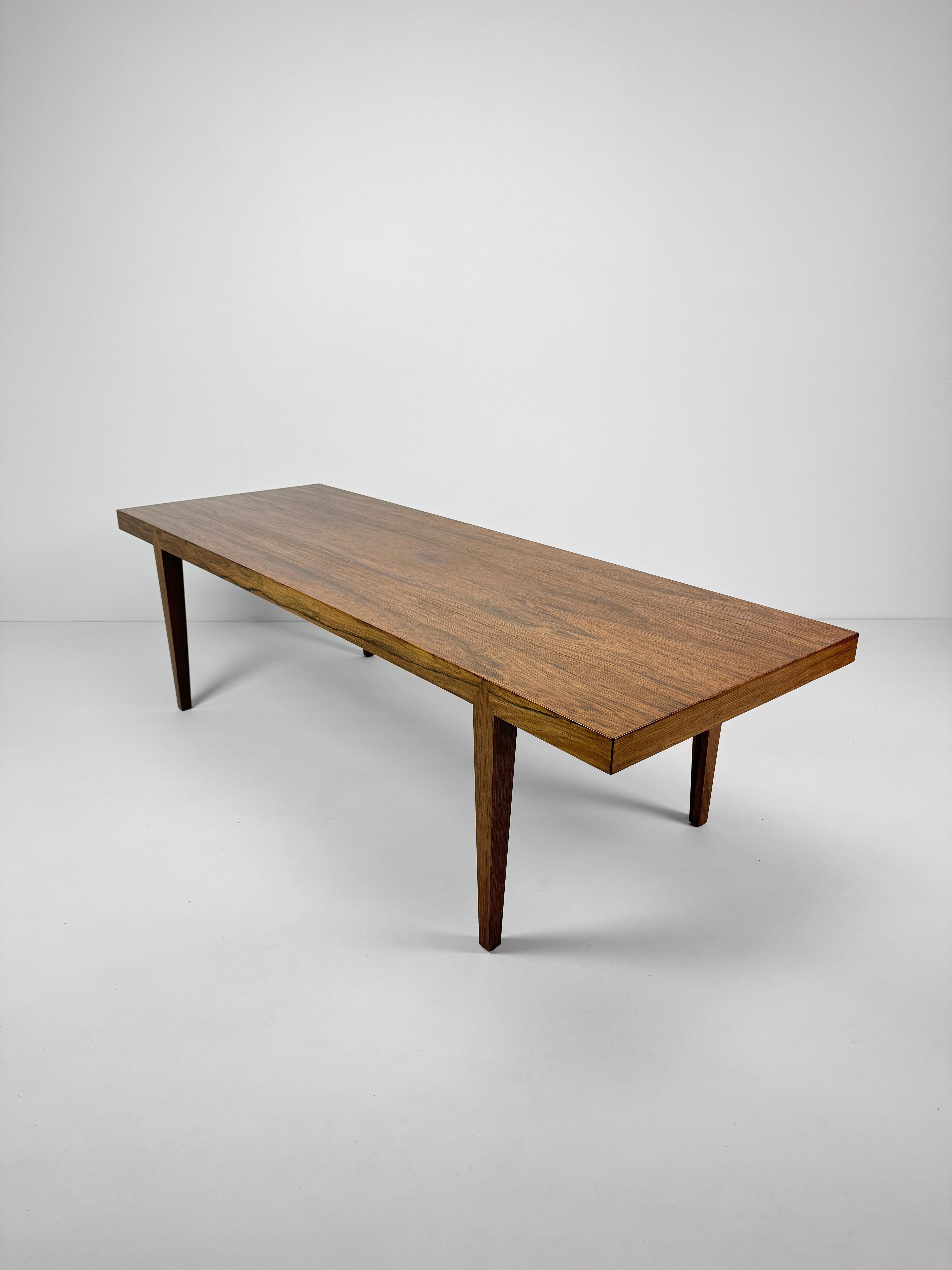 Une table basse Severin Hansen en bois de rose, dont le grain est très expressif et dont les pieds effilés à section carrée, caractéristiques du design Hansen, sont immédiatement reconnaissables et élégants. L'ensemble de la composition et de la