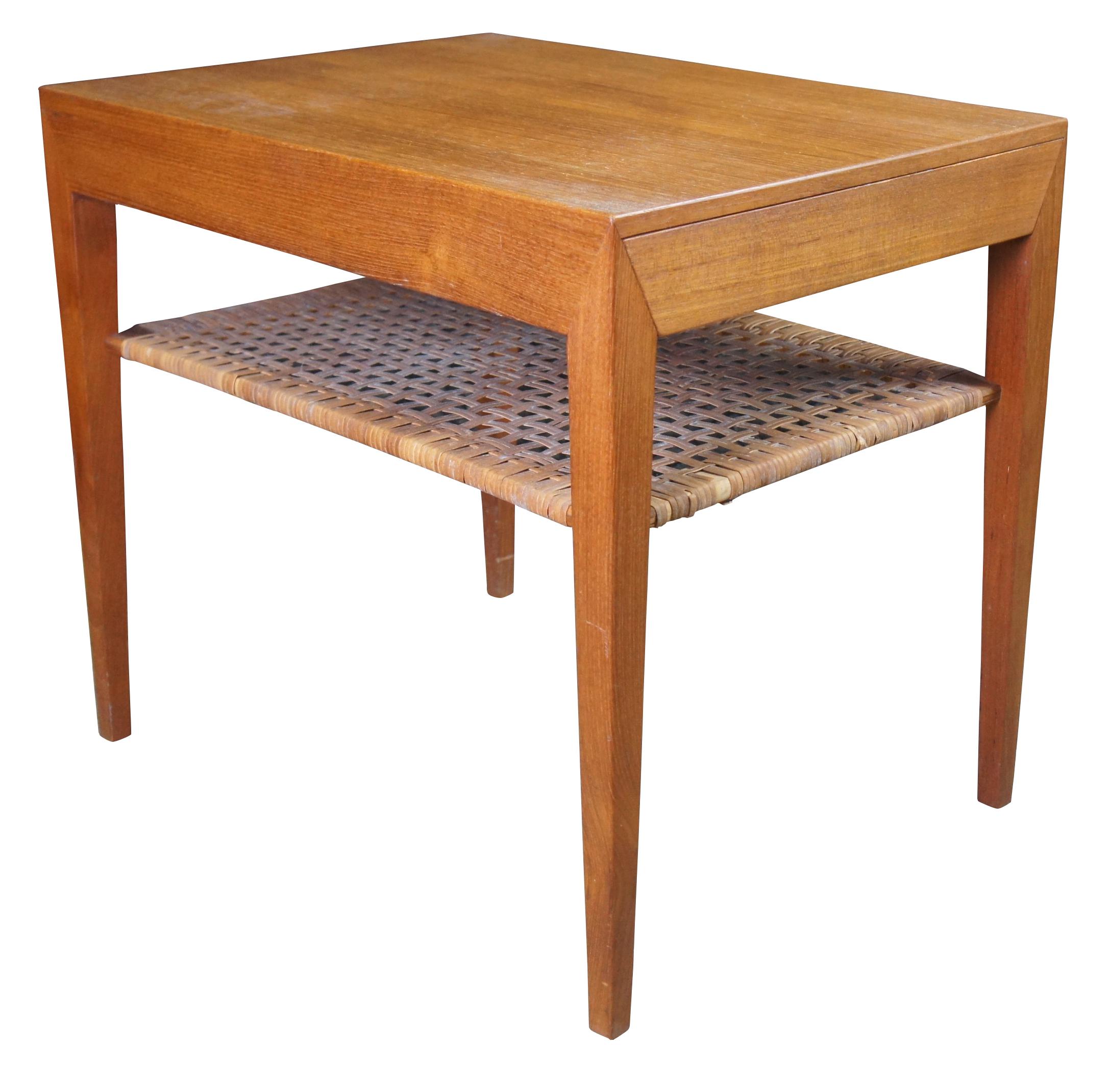 This stunning design was made in the 1950s by Danish Designer Severin Hansen Jr. for Haslev Møbelfabrik (Haslev Furniture), Denmark. The beautiful teak table features an integrated drawer and an elegant shelf in beautifully patinaed woven cane. An