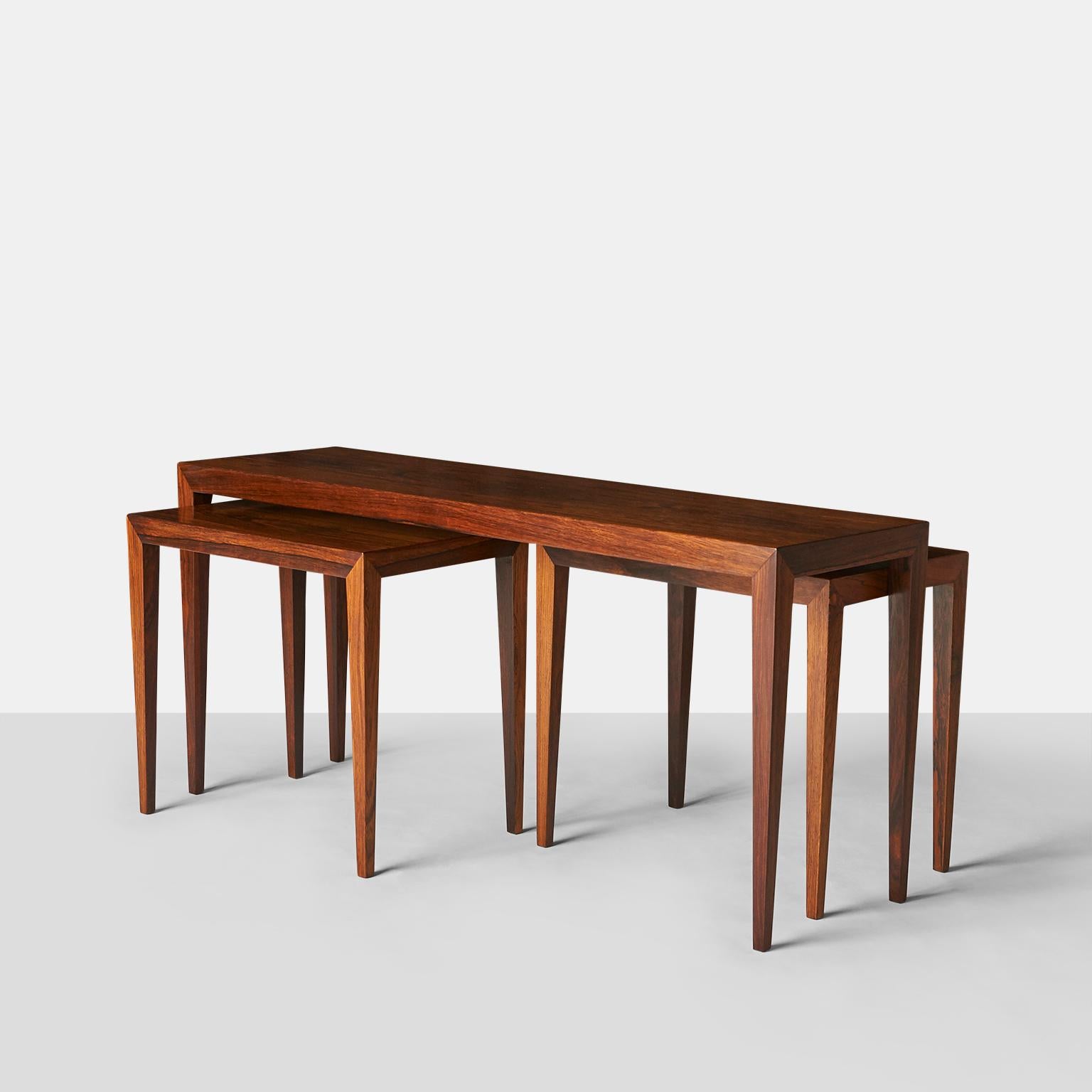 A set of 3 nesting tables in Brazilian Rosewood, by Severin Hansen Jr for Haslev. The smaller tables nest under the larger one side-to-side.