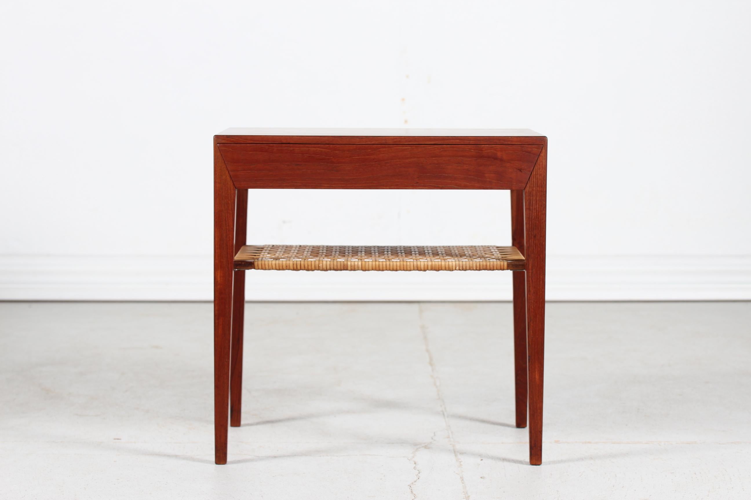 Dänischer moderner kleiner Beistelltisch aus Teakholz mit spitzen Beinen, entworfen von Severin Hansen Jr. und hergestellt von Haslev Furniture in Dänemark in den 1960er Jahren

Der Tisch hat eine Schublade und ein Regal aus Schilfrohr und bleibt