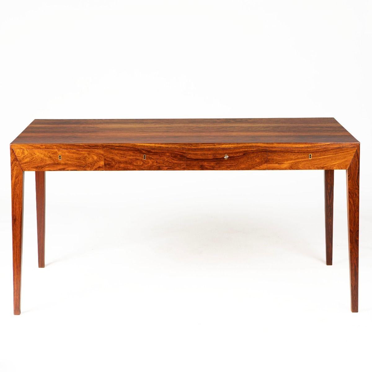Iconic desk, model 36, designed by Severin Hansen and produced by Haslev Møbelfabrik in 1958.
Crafted in veneered and solid Rosewood – an exclusive wood known for its deep color and unique grain pattern.

The simple yet elegant design features four