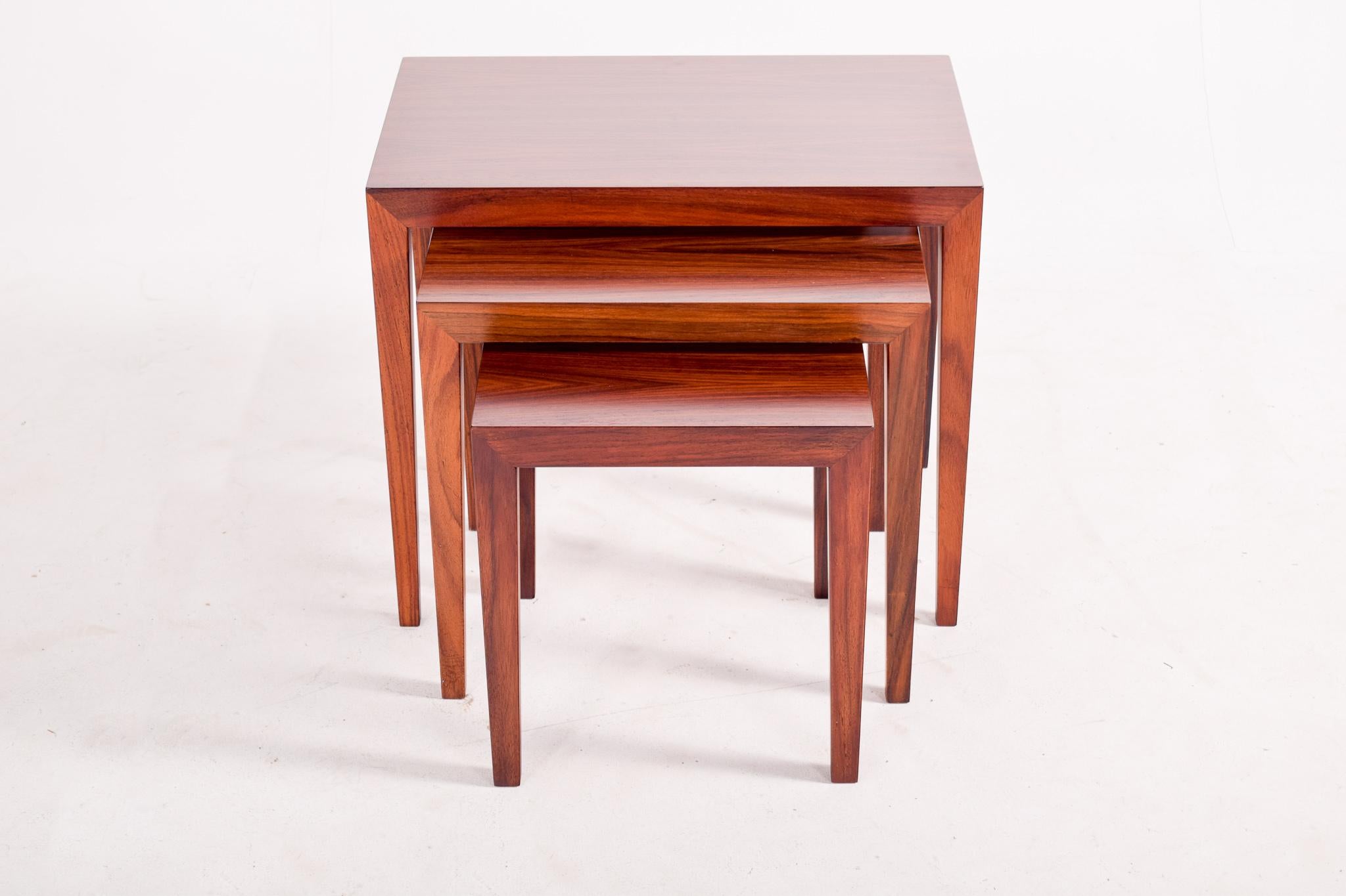 A gorgeous set of nesting tables in rosewood designed by Severin Hansen Jr. for Haslev Møbelsnedskeri. His mark on corner joinery is what makes these pieces stand out with a minimalistic design. These could be used in many different ways such as a